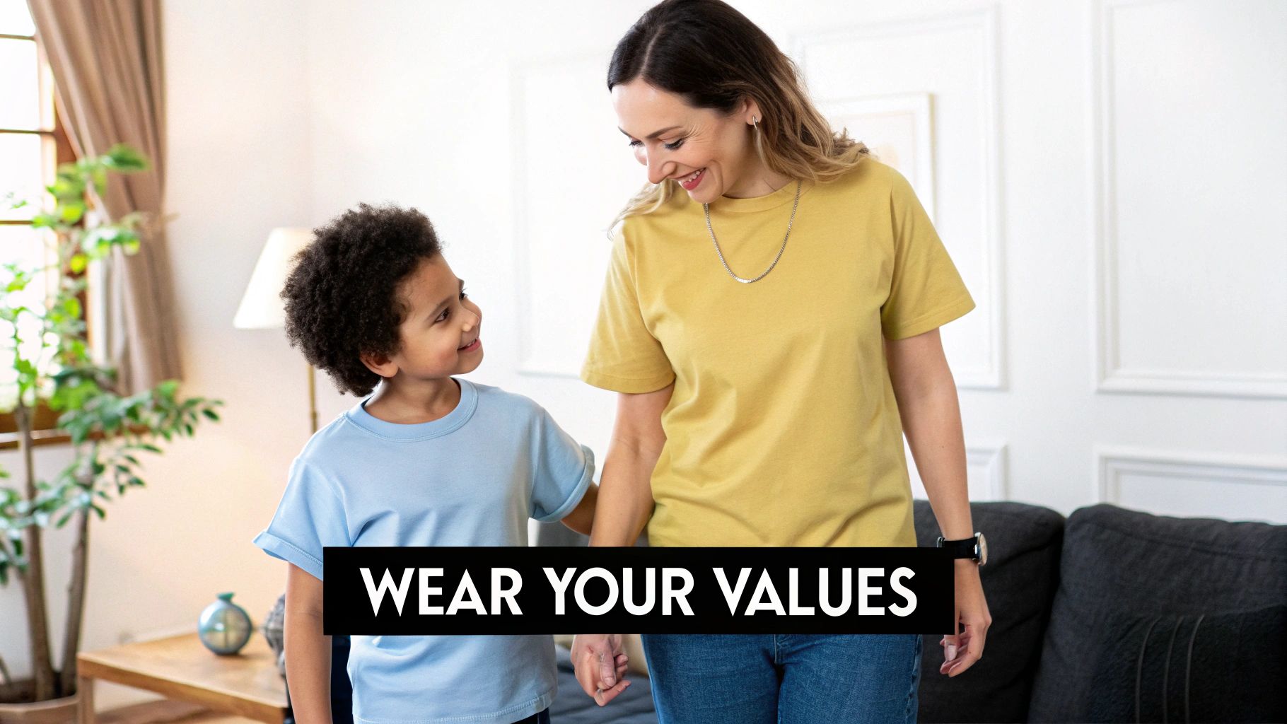 A smiling mother and child, both wearing comfortable cotton t-shirts, holding hands indoors.