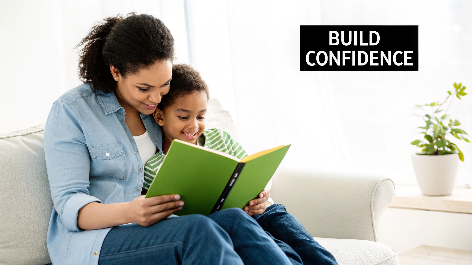 A happy mother and child sitting on a sofa, reading a green book together.