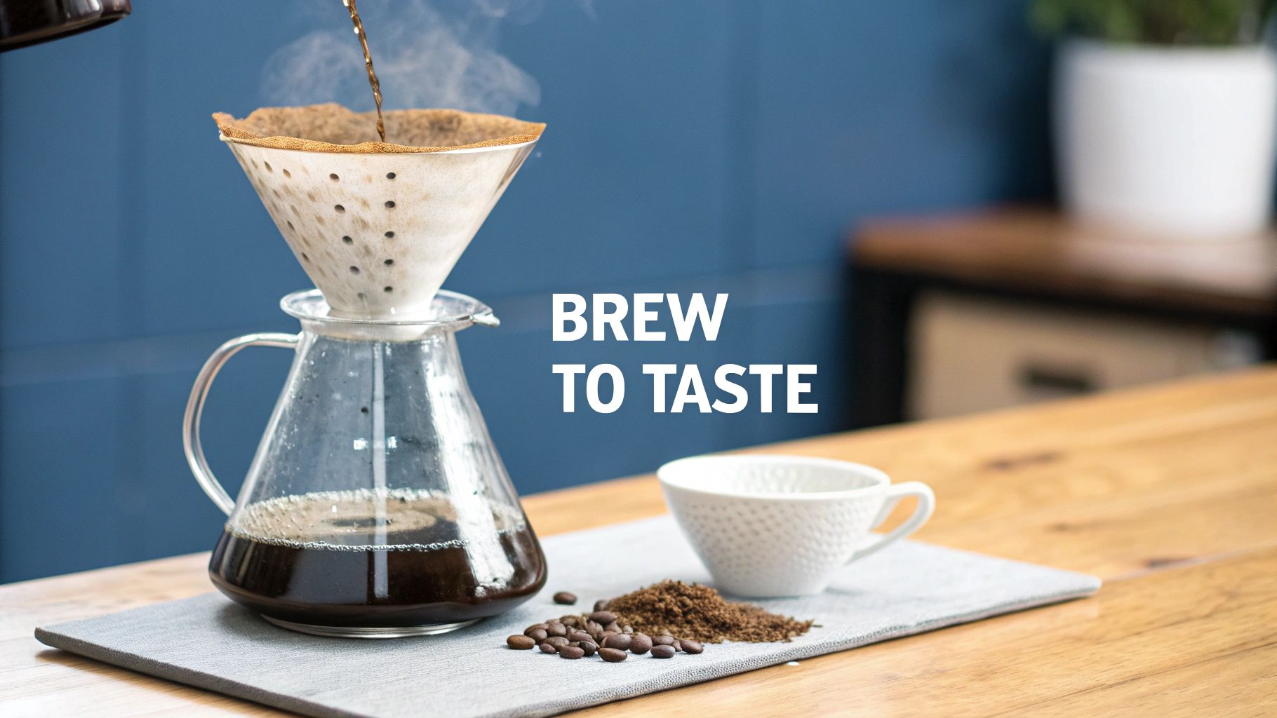 A pour-over coffee setup with coffee brewing into a glass carafe, surrounded by beans and ground coffee.