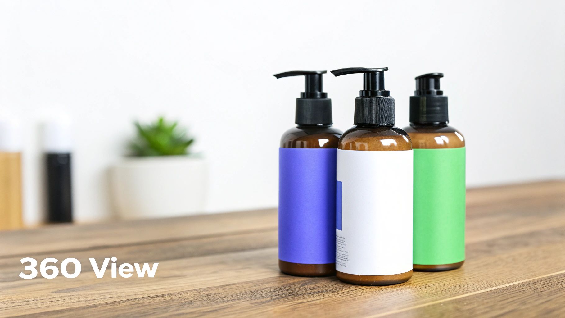 Three amber pump bottles with blue, white, and green labels sit on a rustic wooden table.