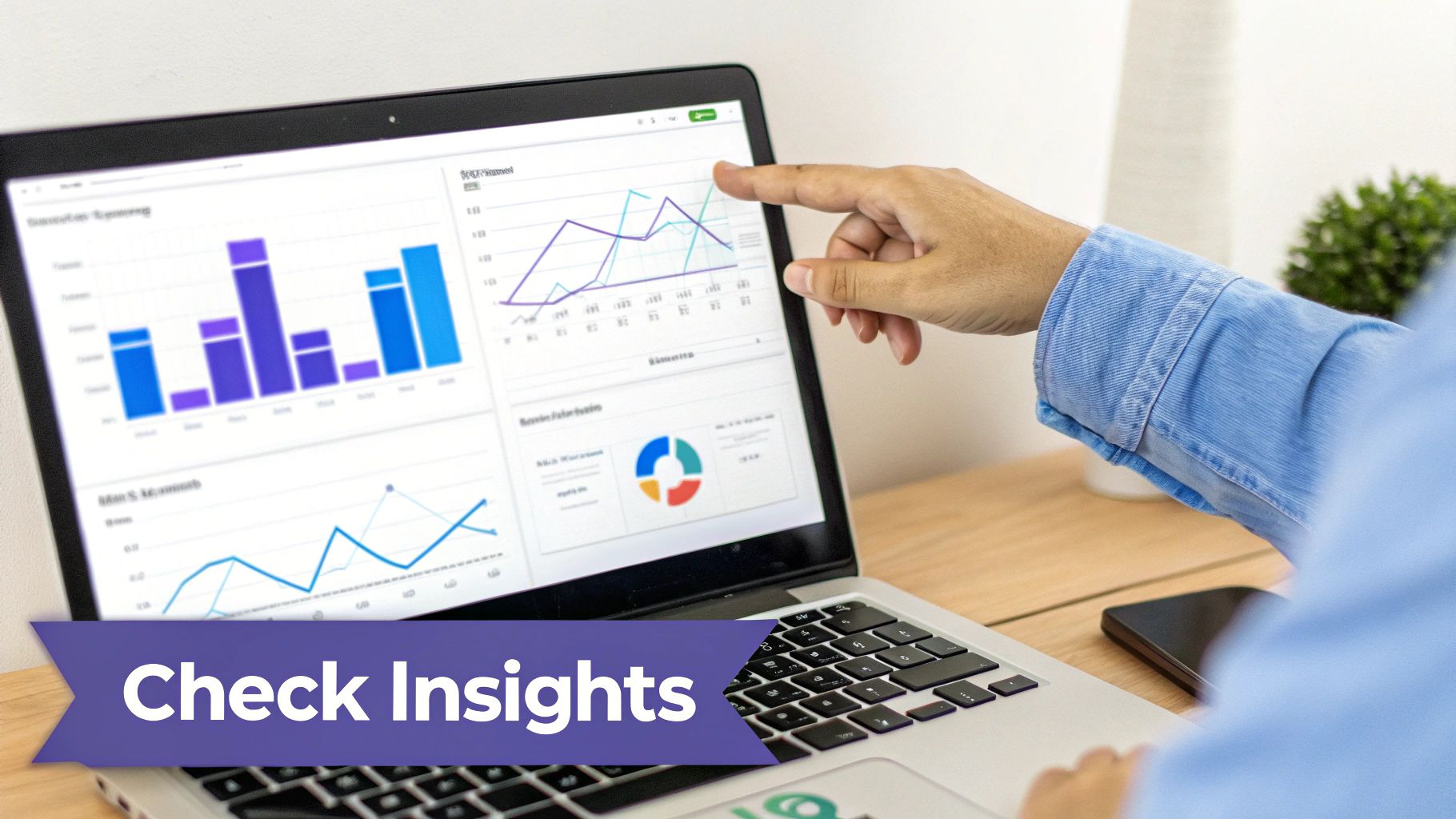 A person pointing at a laptop screen showing business insights and data analytics charts.