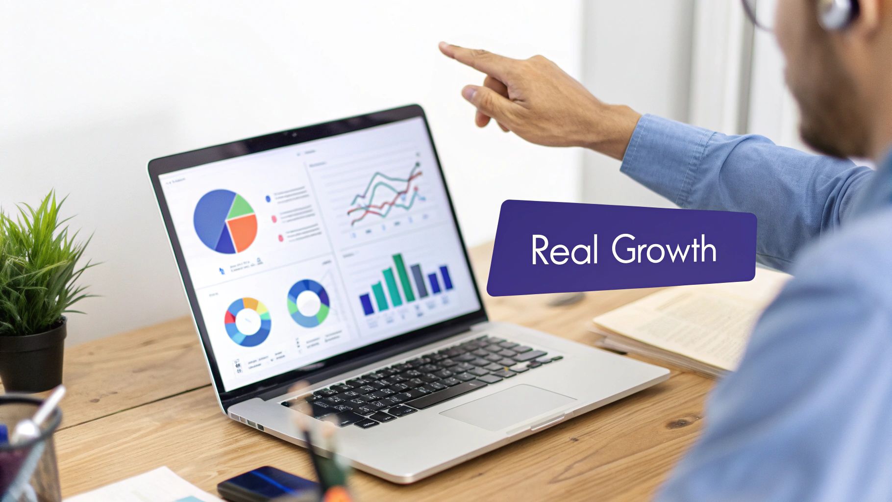 A person points at a laptop displaying business analytics charts and graphs, emphasizing 'Real Growth'.