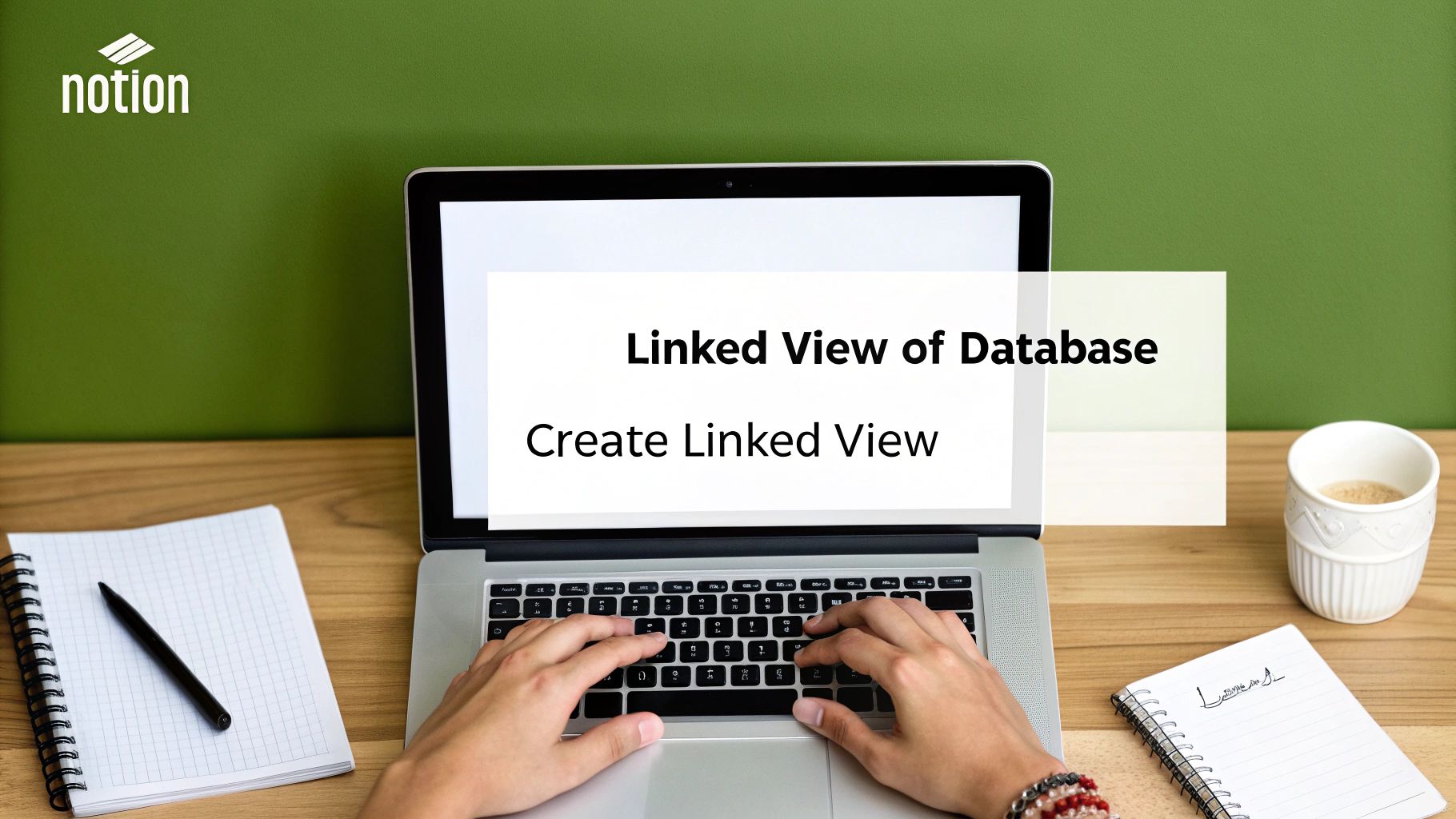 Hands typing on a laptop showing a Notion page about creating a linked view of a database.