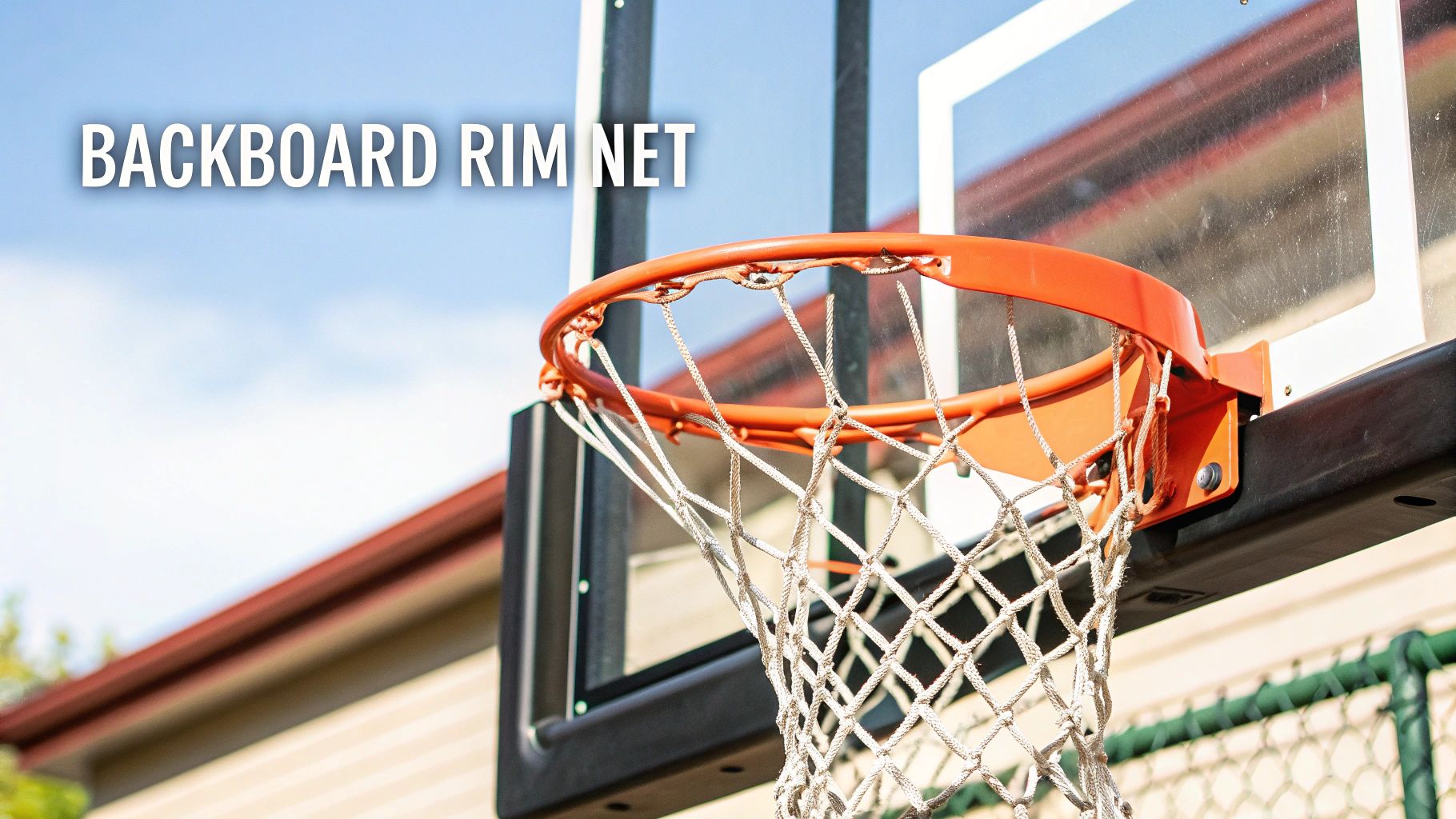 Basketball hoop with white net attached to weathered backboard mounted on outdoor residential pole