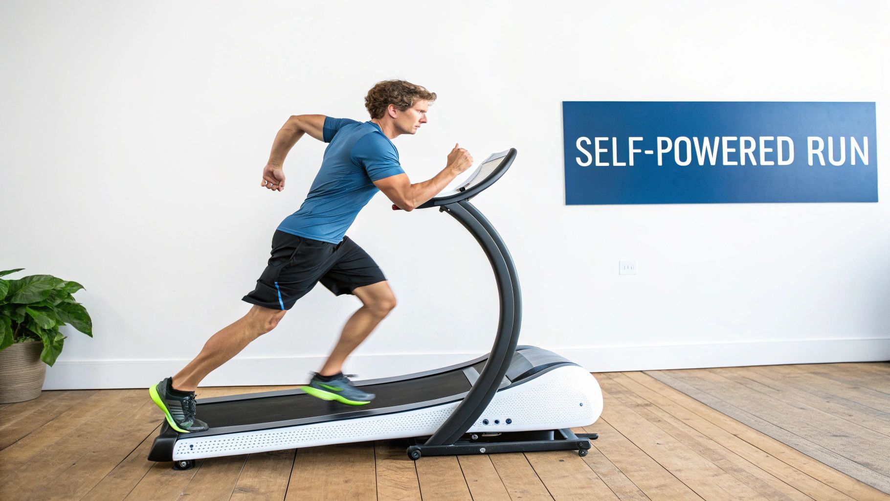 A man performs a self-powered run on a curved treadmill in a bright white room.