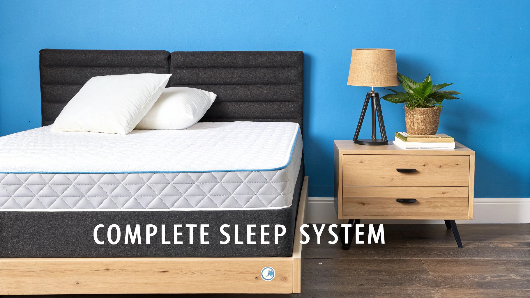 A complete sleep system featuring a bed with a white mattress, two pillows, and a wooden nightstand.
