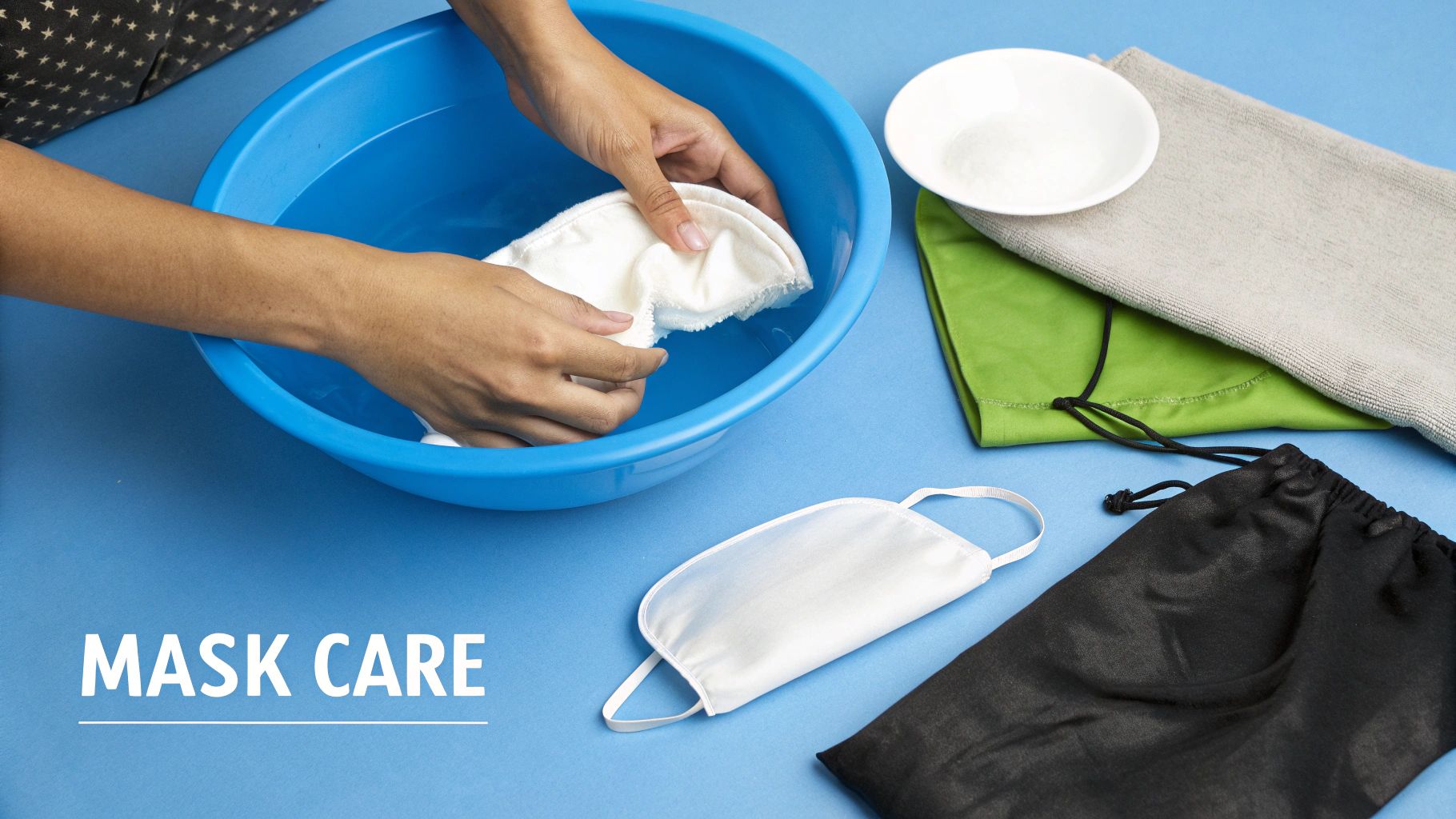 Hands washing a white sleep mask in a blue bowl, with other masks and care items.