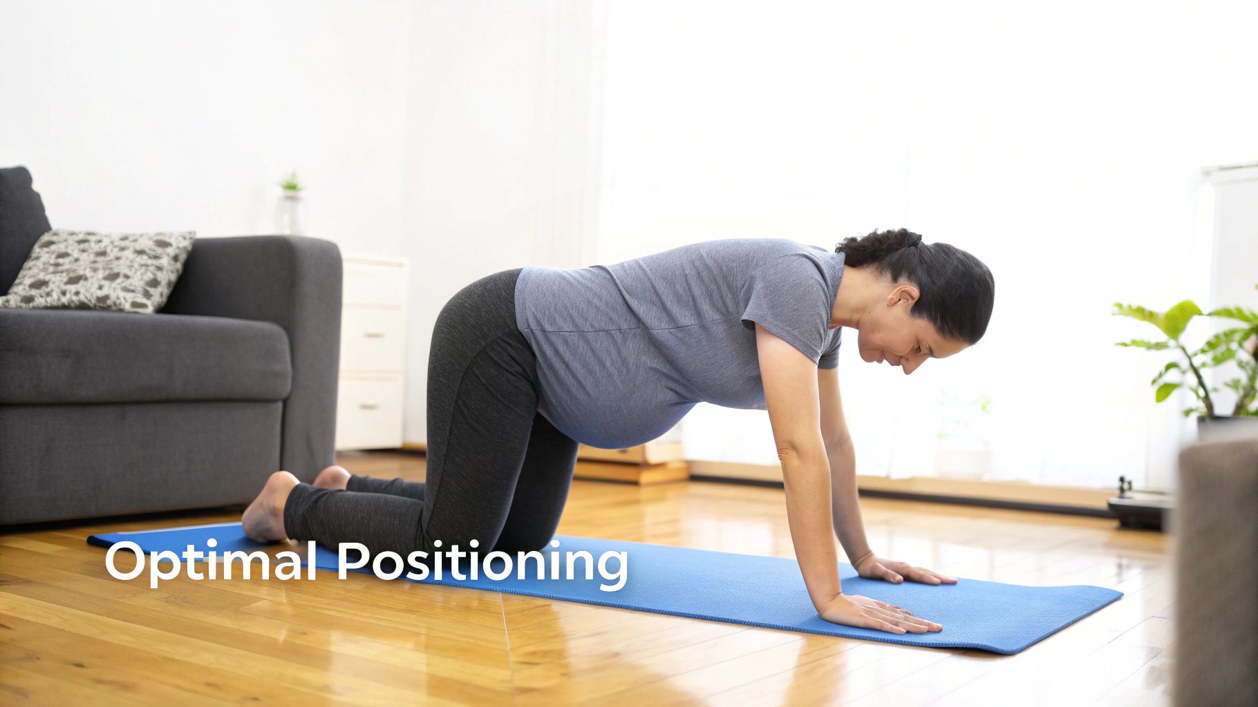 A pregnant woman in a living room performing an exercise on a blue yoga mat, in an all-fours position.