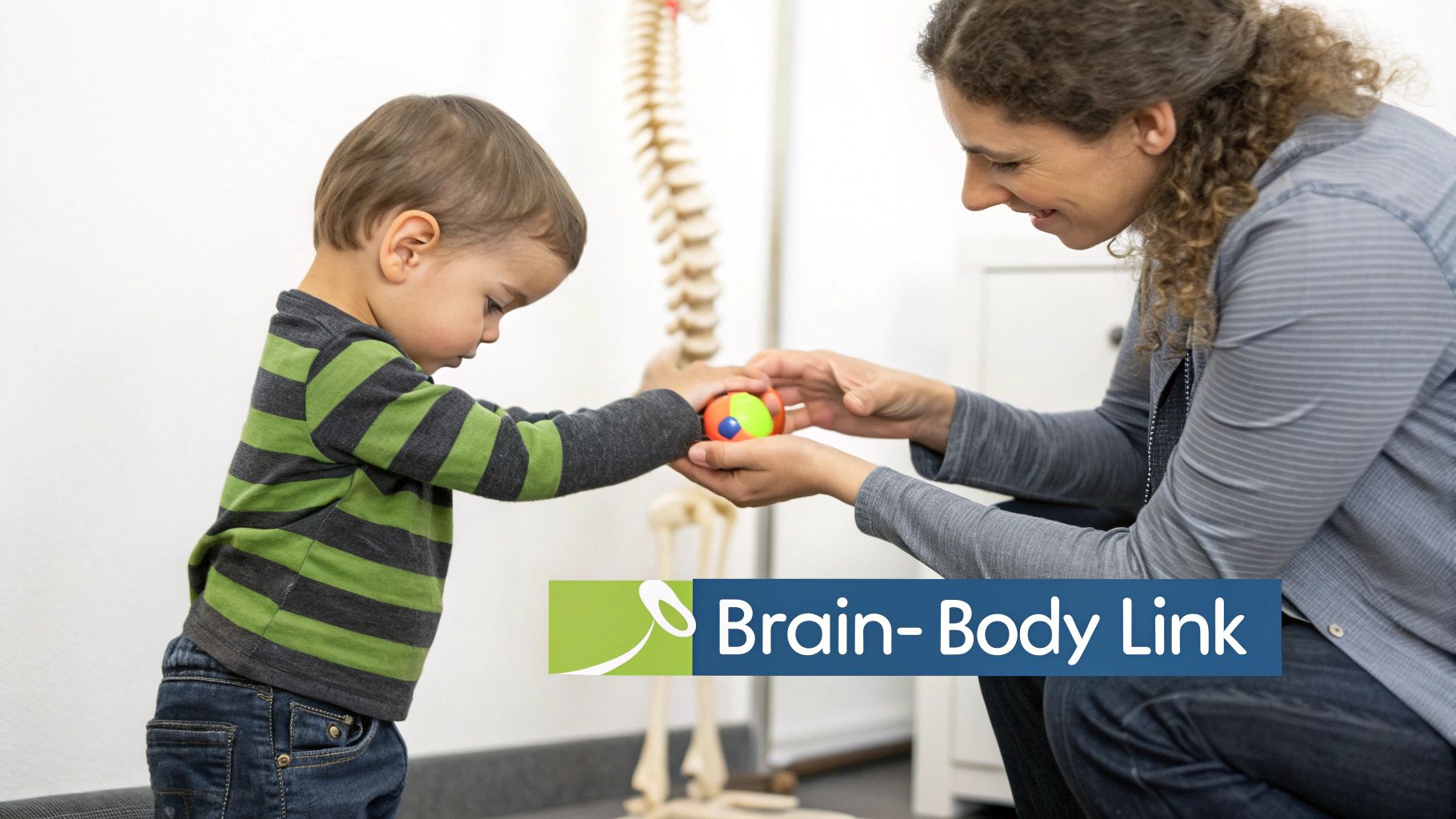A smiling woman and a young child playing with a colorful ball near a skeleton model.