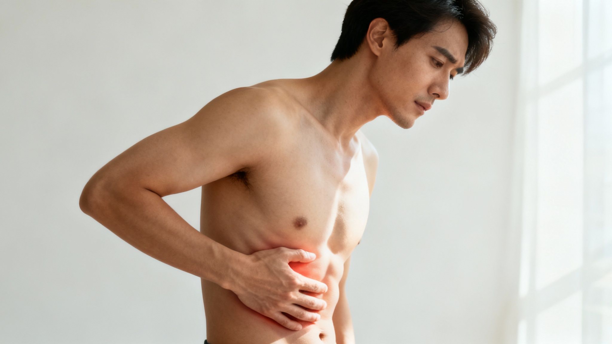 Personne ressentant une douleur sous les côtes, tenant la zone du diaphragme avec une expression de gêne.
