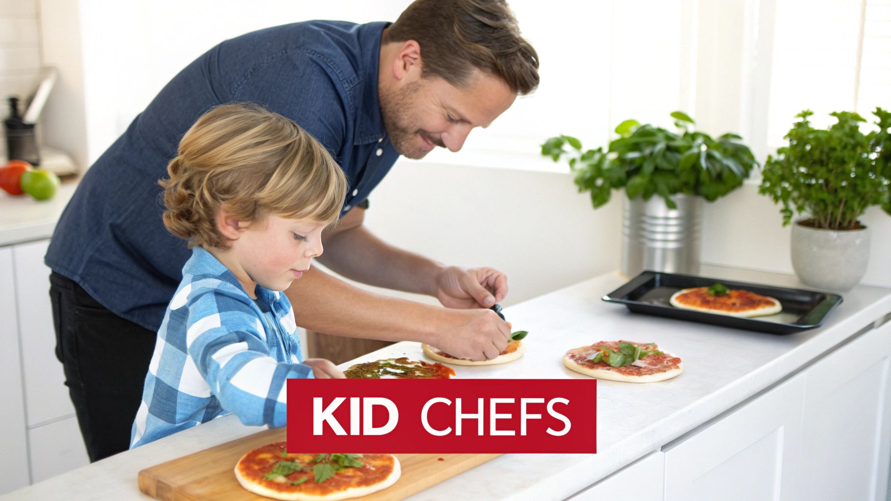 A happy father and his young son making small pizzas together in a bright kitchen.