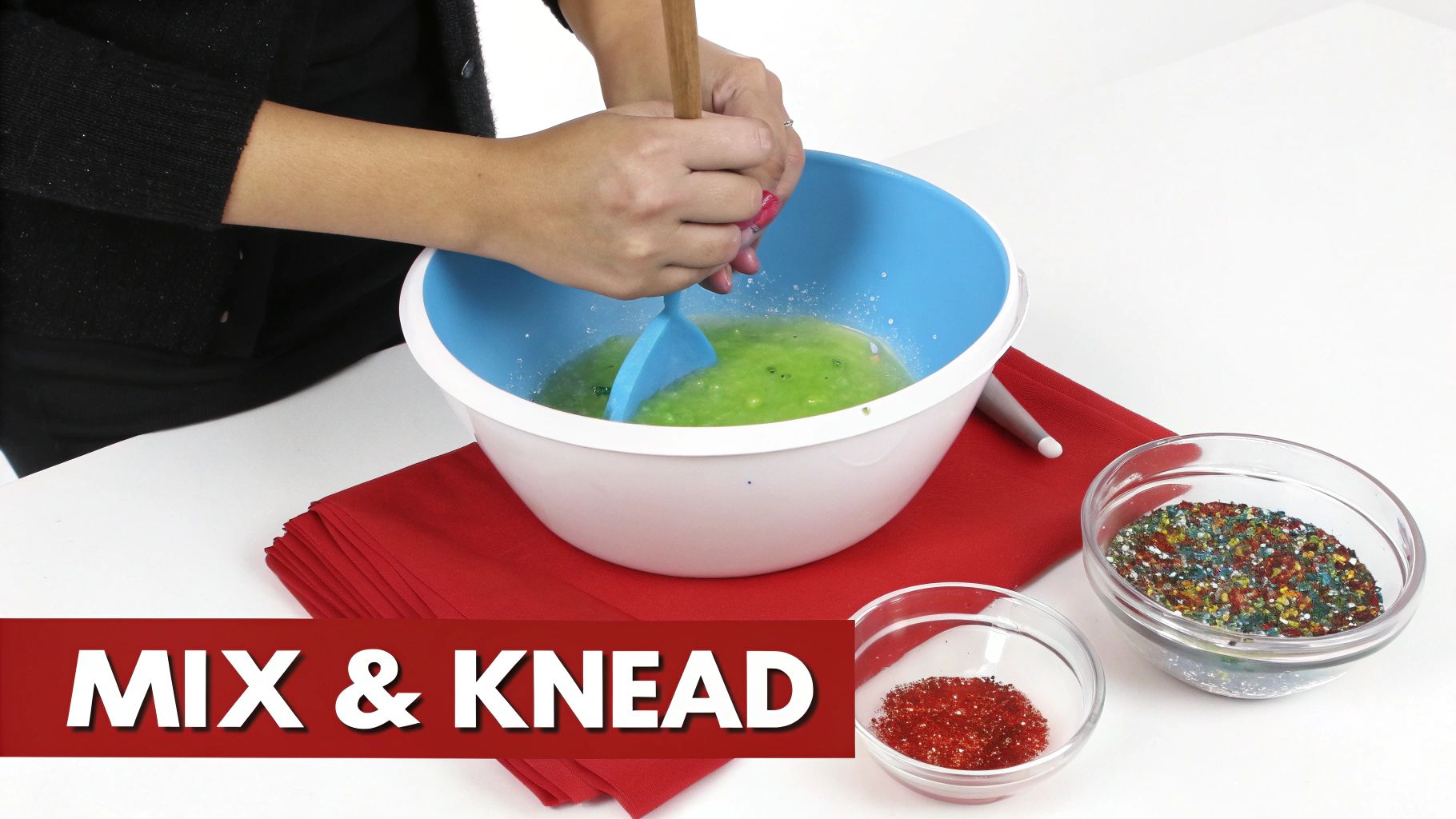 Hands mixing green slime in a blue bowl with a spatula, surrounded by colorful sprinkles.