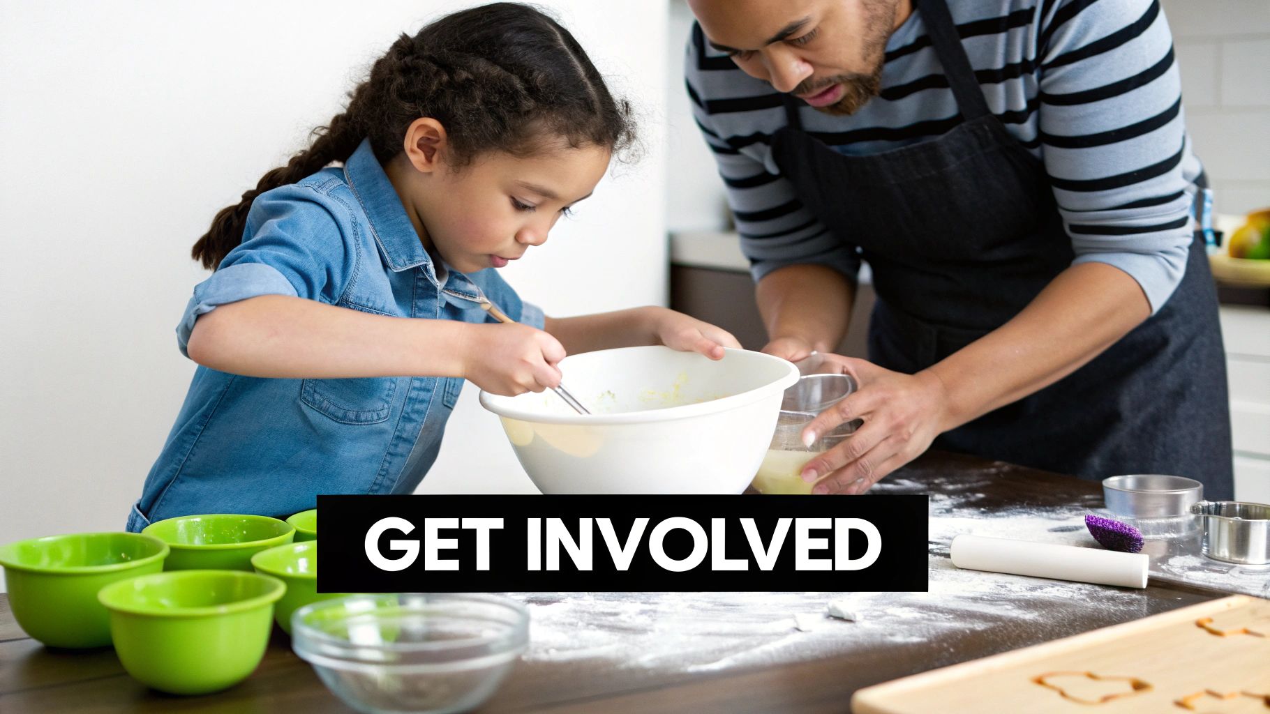 A father and young daughter are baking in the kitchen, mixing ingredients in a bowl.