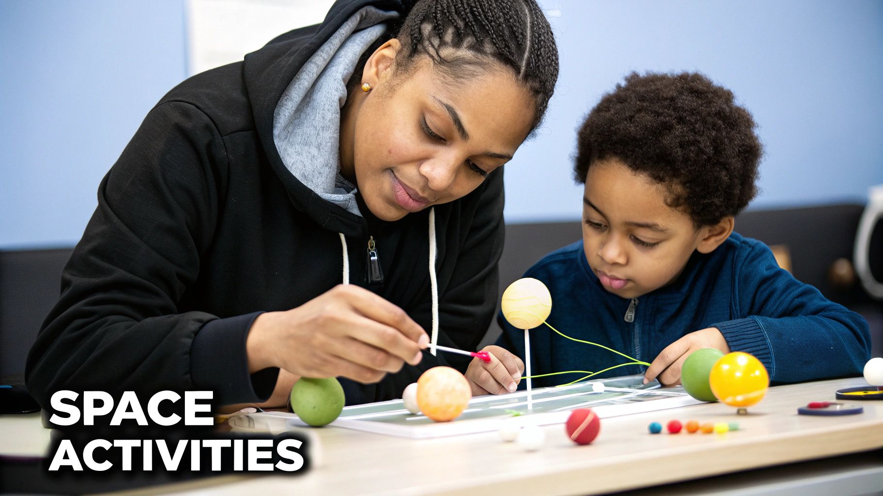 An adult and child build a colorful planet model together during a space activity.