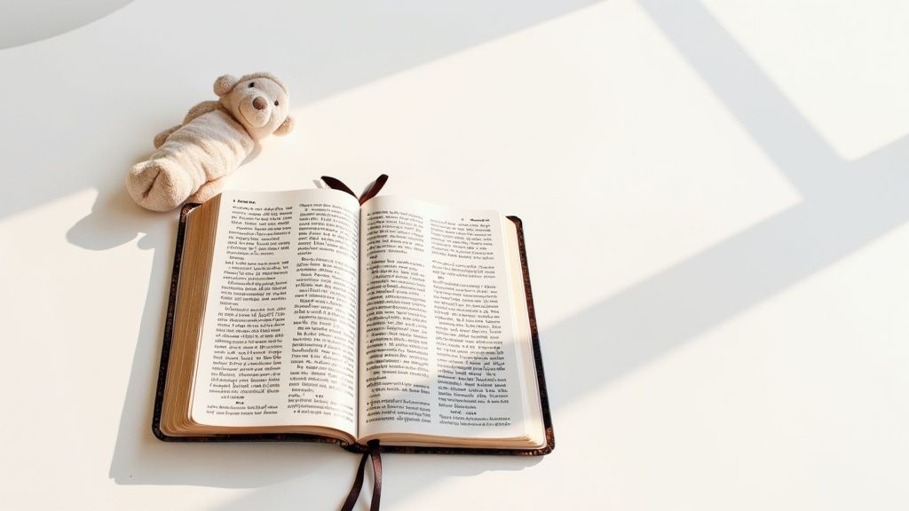 Open Bible with brown leather cover and small teddy bear on white surface
