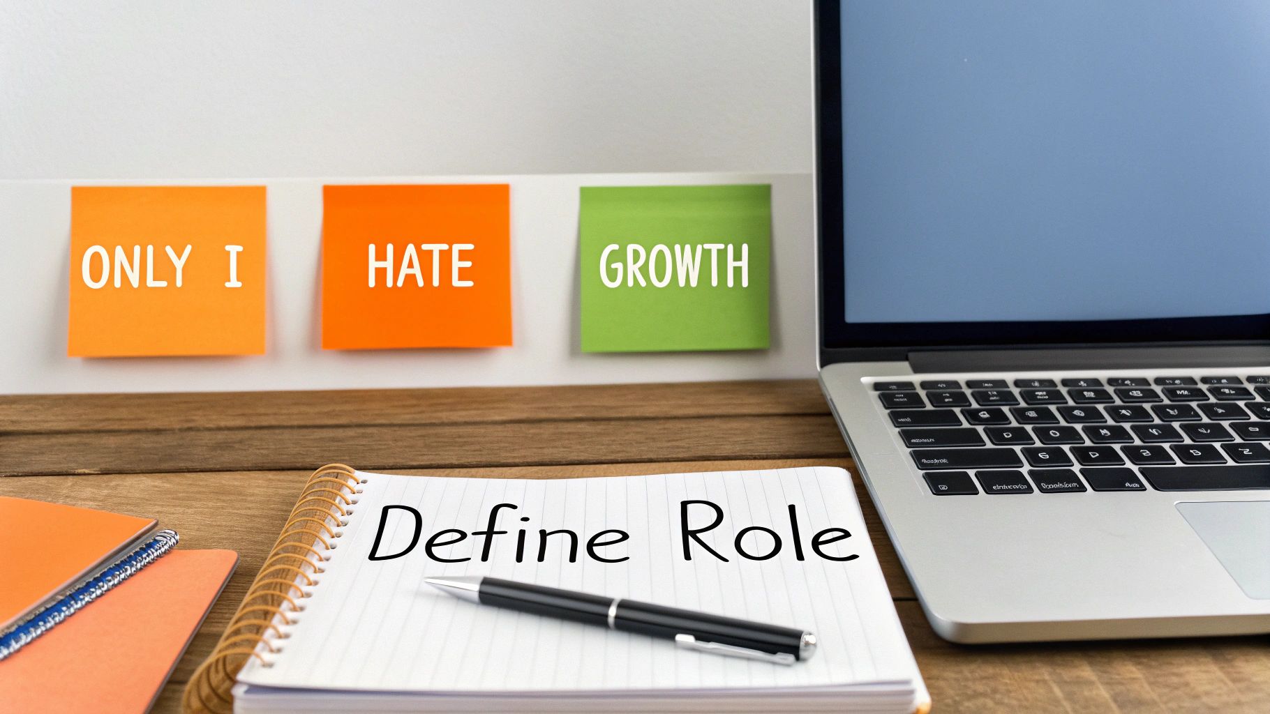 A desk with a laptop, a notebook reading 'Define Role', and sticky notes saying 'ONLY I HATE GROWTH'.