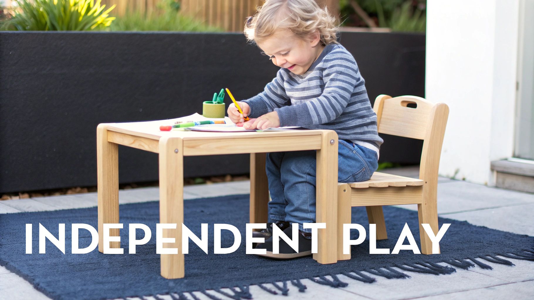 A toddler sitting at a wooden table and chair set, focused on an activity with colorful blocks.