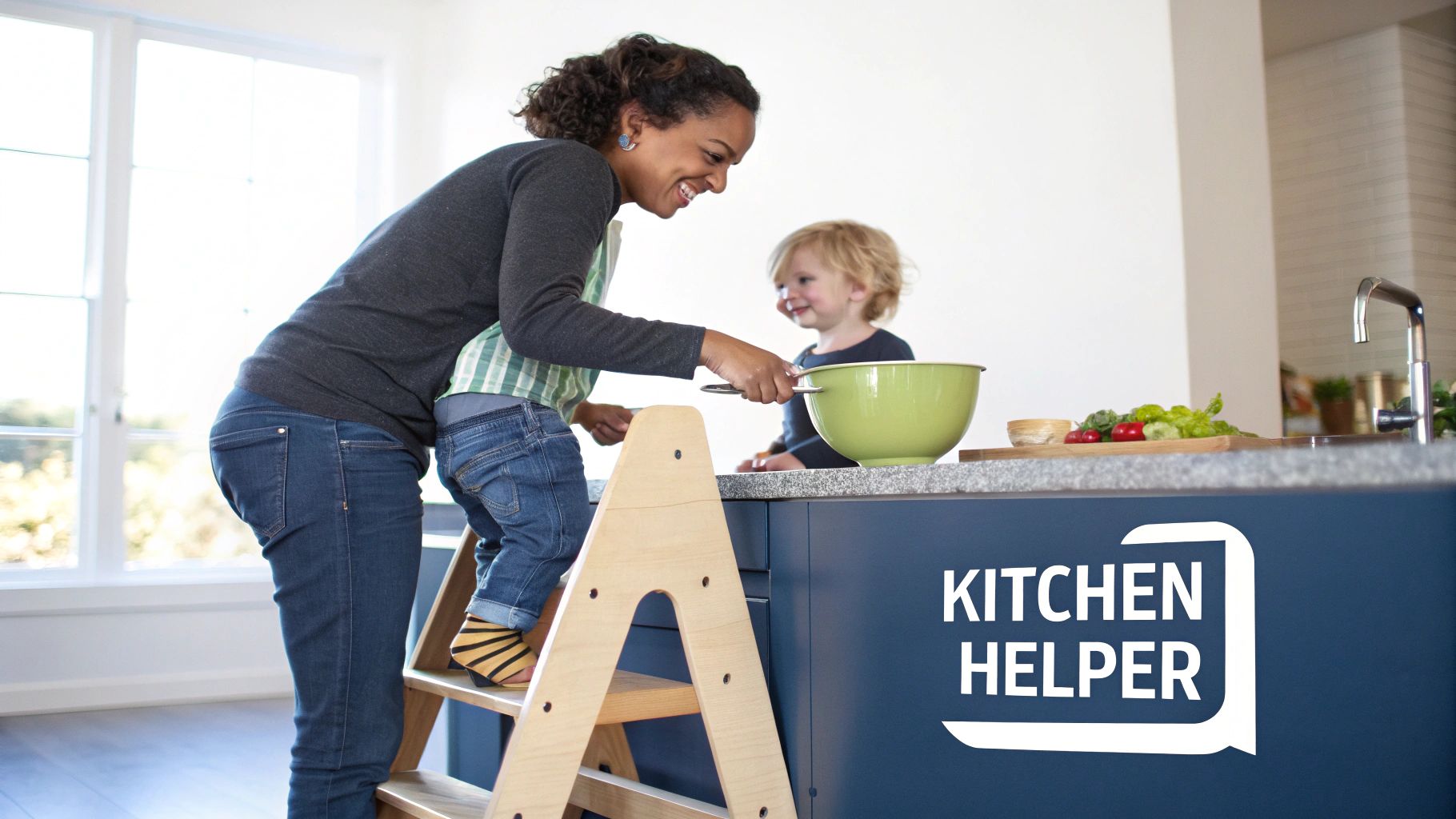 A happy mother helps her child on a kitchen helper tower, preparing food together in a bright kitchen.
