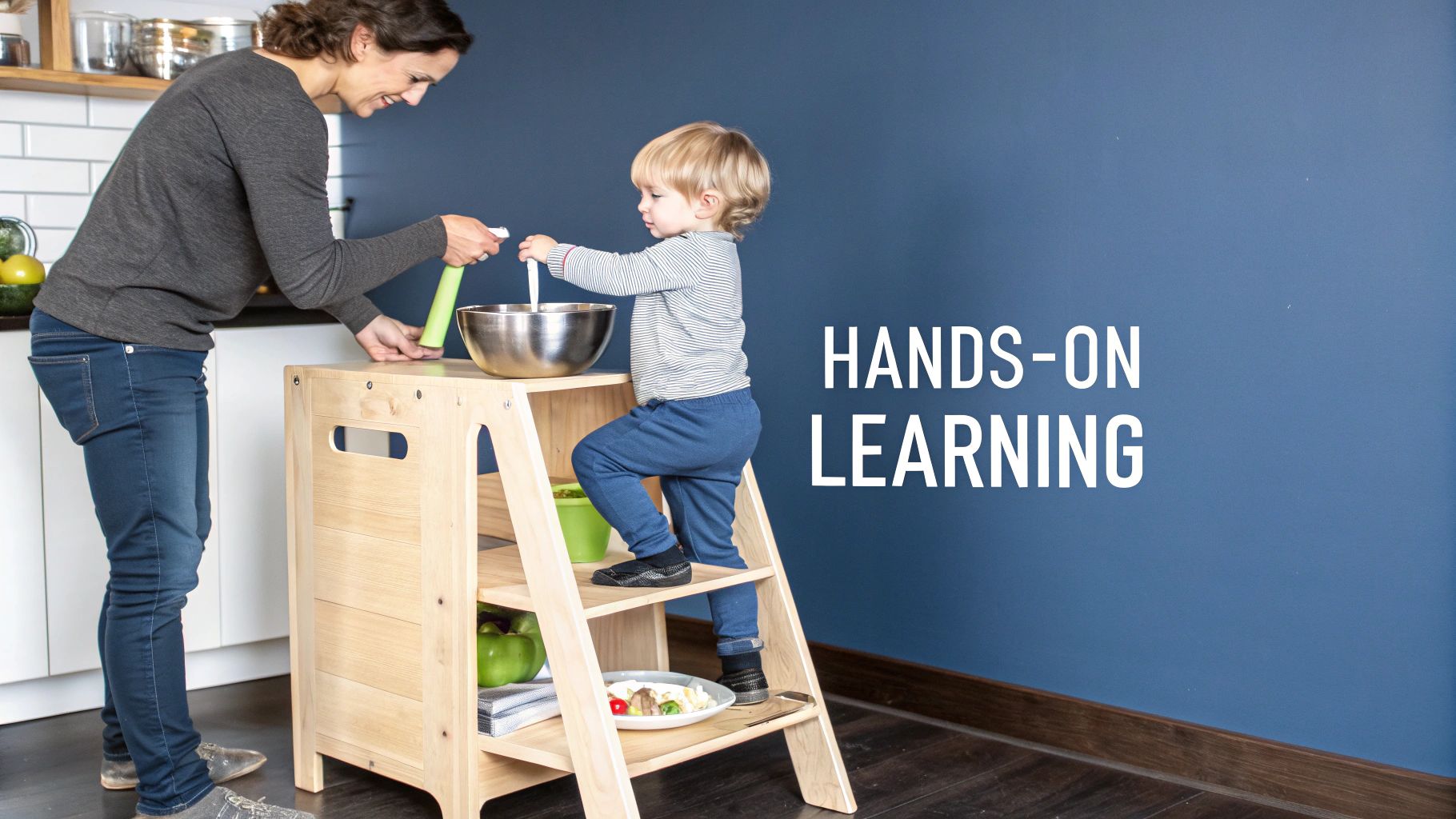 A mother guides her toddler using a wooden kitchen helper tower for hands-on cooking and learning.