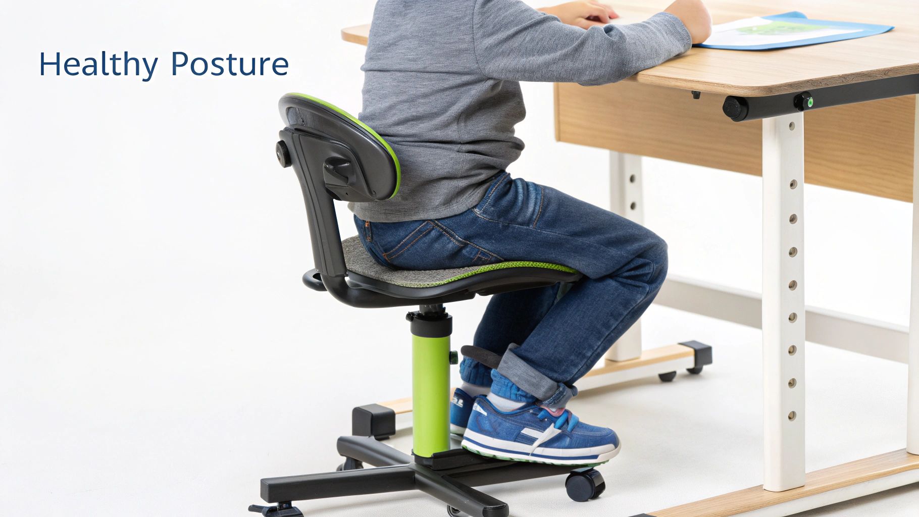 Healthy posture demonstrated by a child sitting in a green and grey adjustable ergonomic chair at a desk.