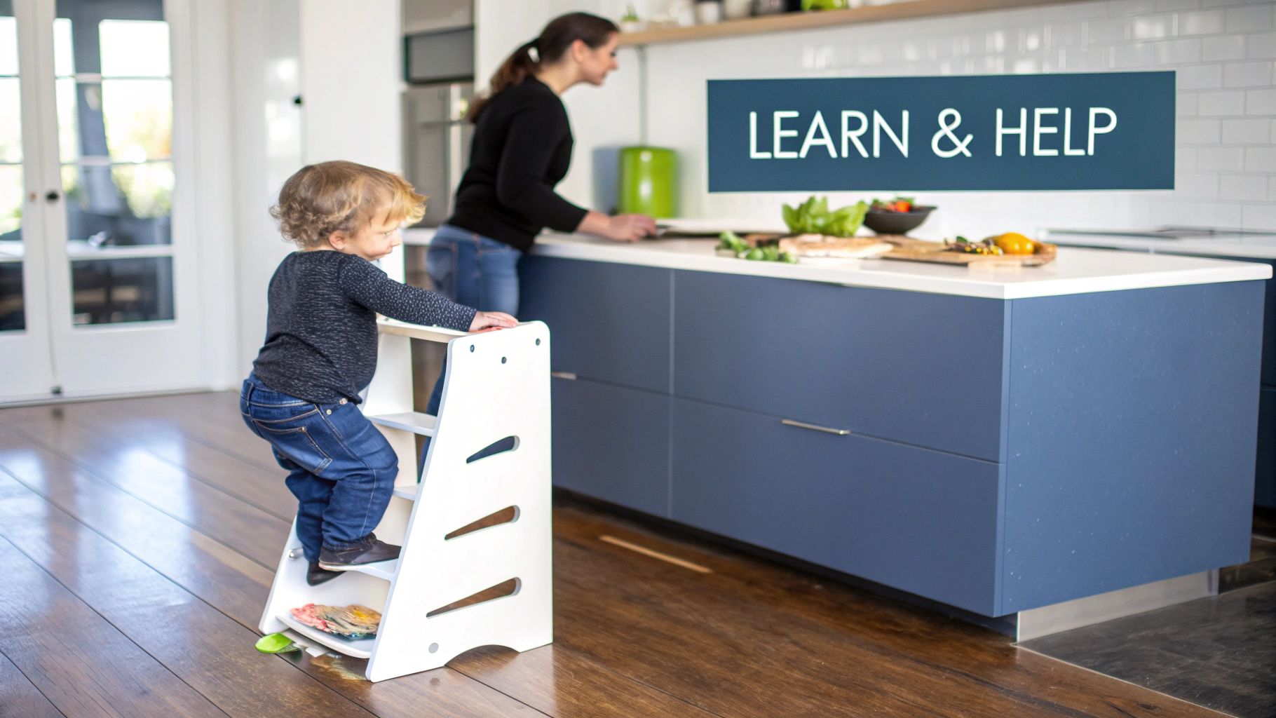 A toddler on a white learning tower observes an adult preparing food in a modern kitchen.