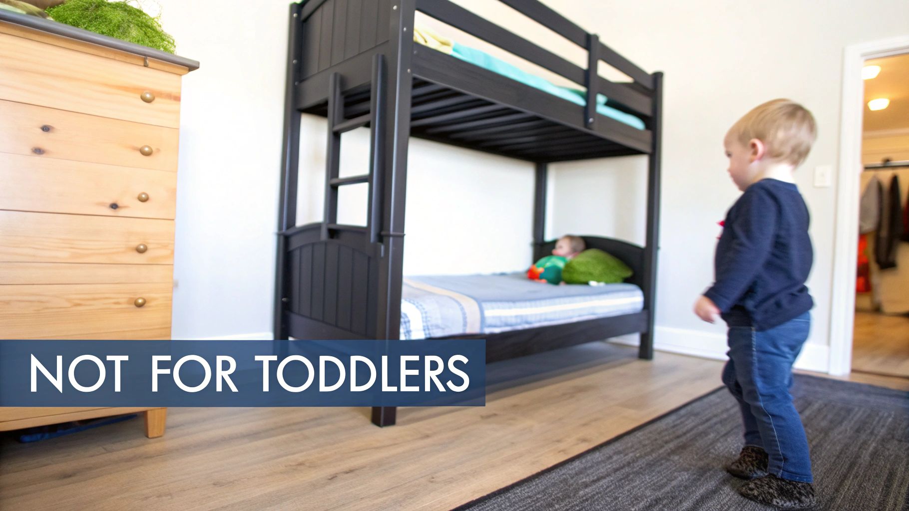 Toddler stands near a black bunk bed, with a dresser nearby, and a 'NOT FOR TODDLERS' warning overlay.