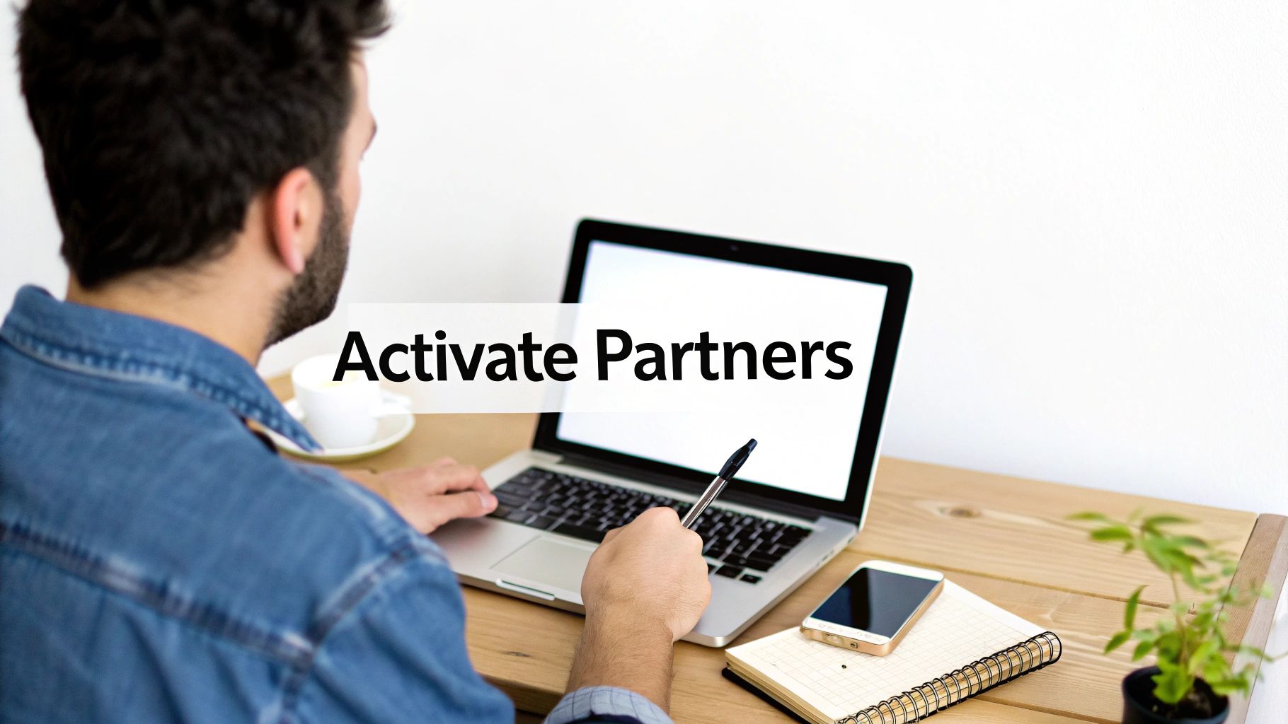Two people shaking hands over a desk with laptops and paperwork, symbolizing a new affiliate partnership