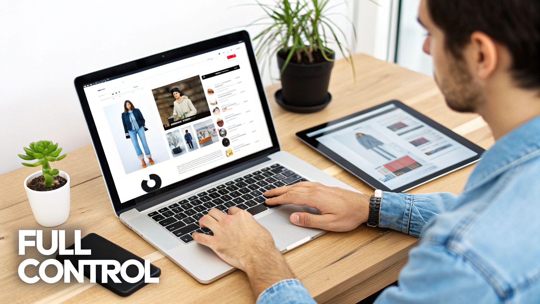 Man typing on laptop with e-commerce fashion website, tablet, and smartphone on wooden desk.