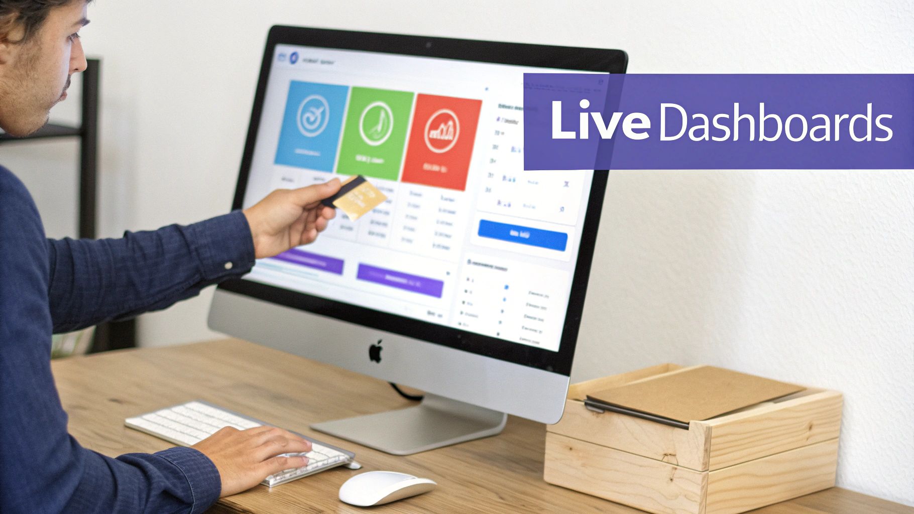 Man viewing live dashboards on a computer screen, holding a credit card and using a keyboard.