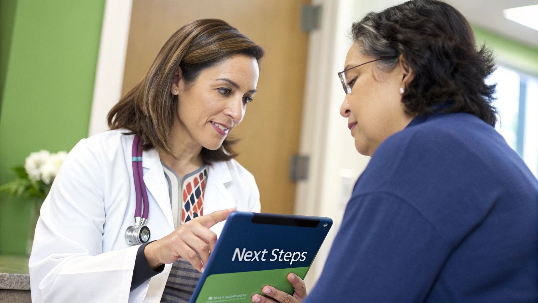 A person reviewing their health check results on a digital tablet with a healthcare professional.
