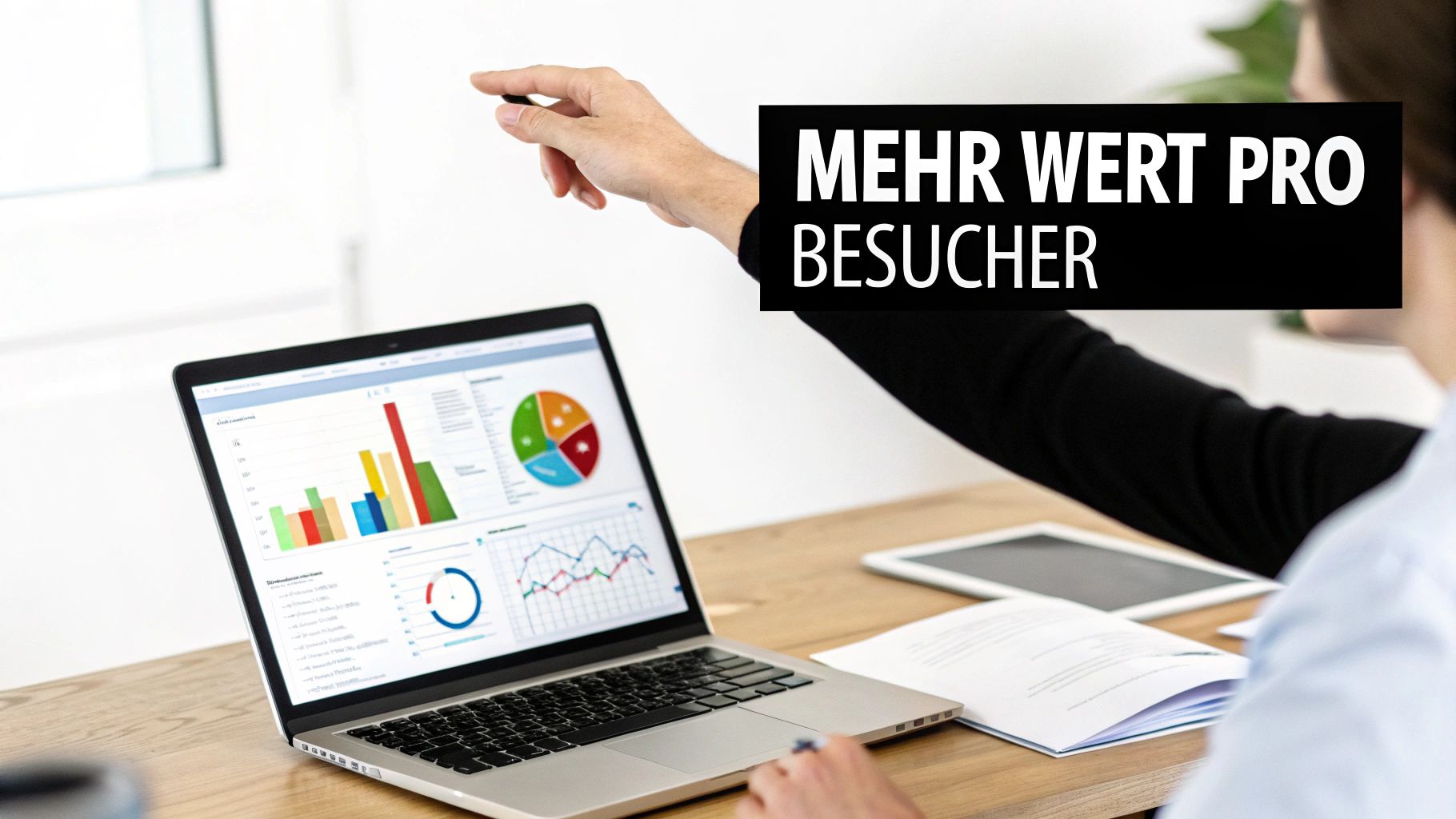A person points to a laptop screen displaying data analysis charts and the text 'More value per visitor'.