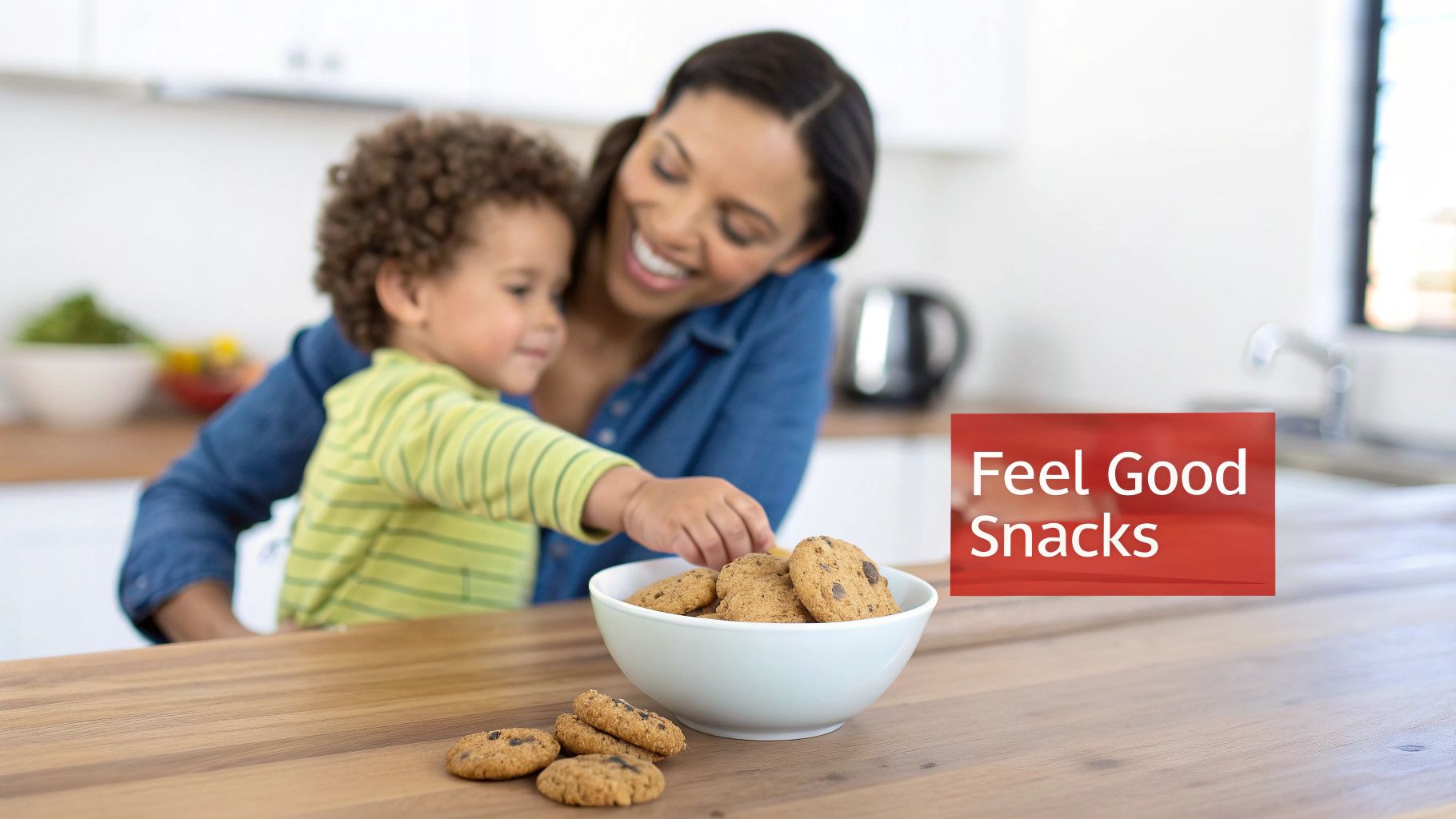 A smiling mother and child in a kitchen, reaching for chocolate chip cookies in a white bowl.