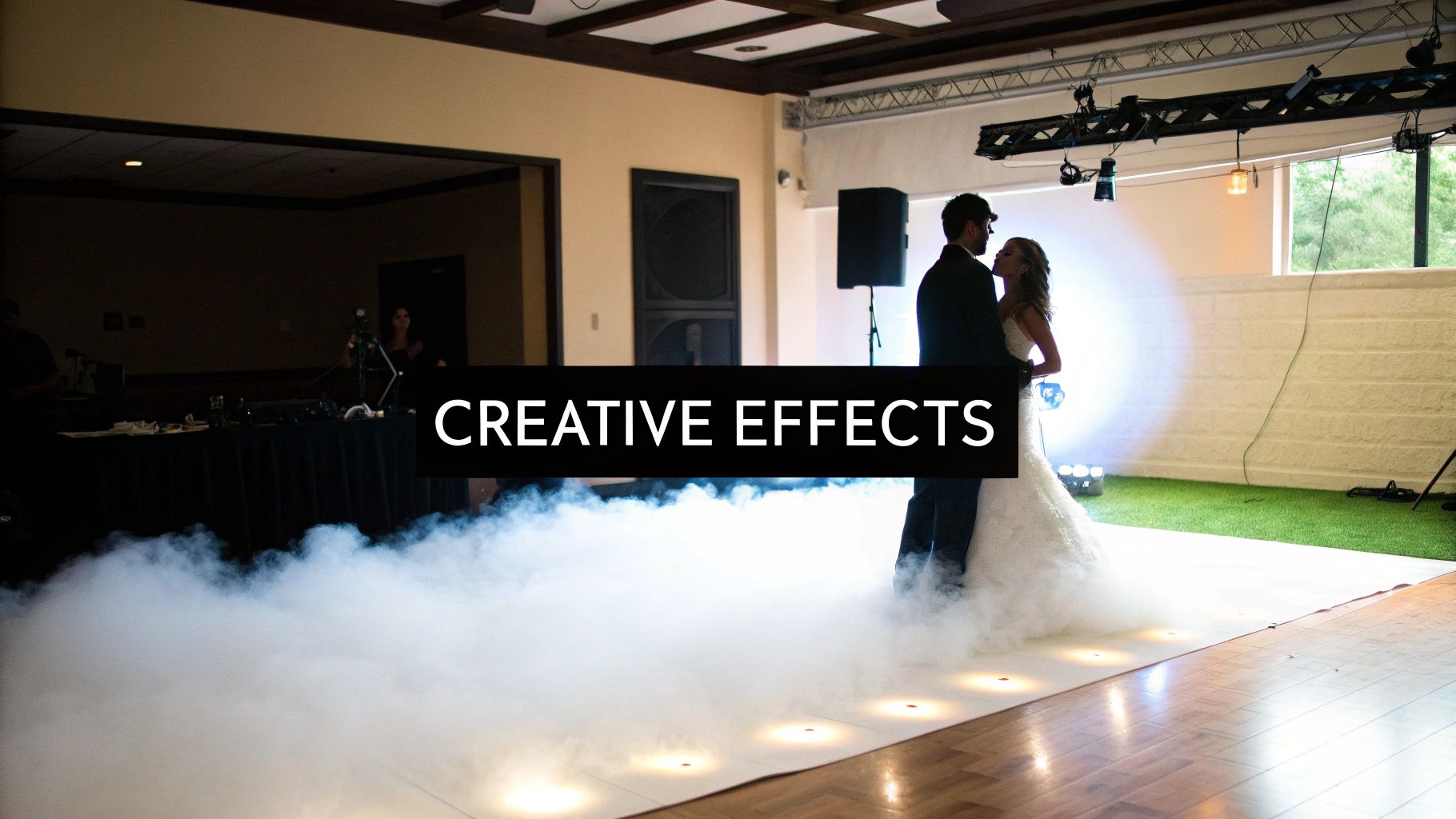 A bride and groom dance on a smoky dance floor, enhanced by creative lighting effects.
