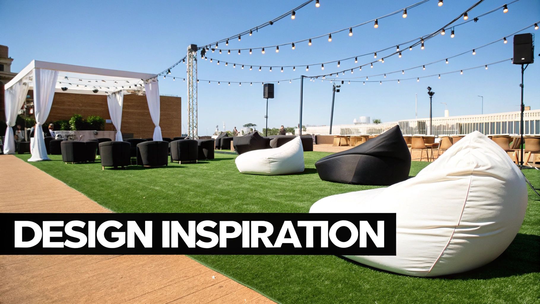 Rooftop event space with artificial grass, comfortable seating, white pergola, and festive string lights.