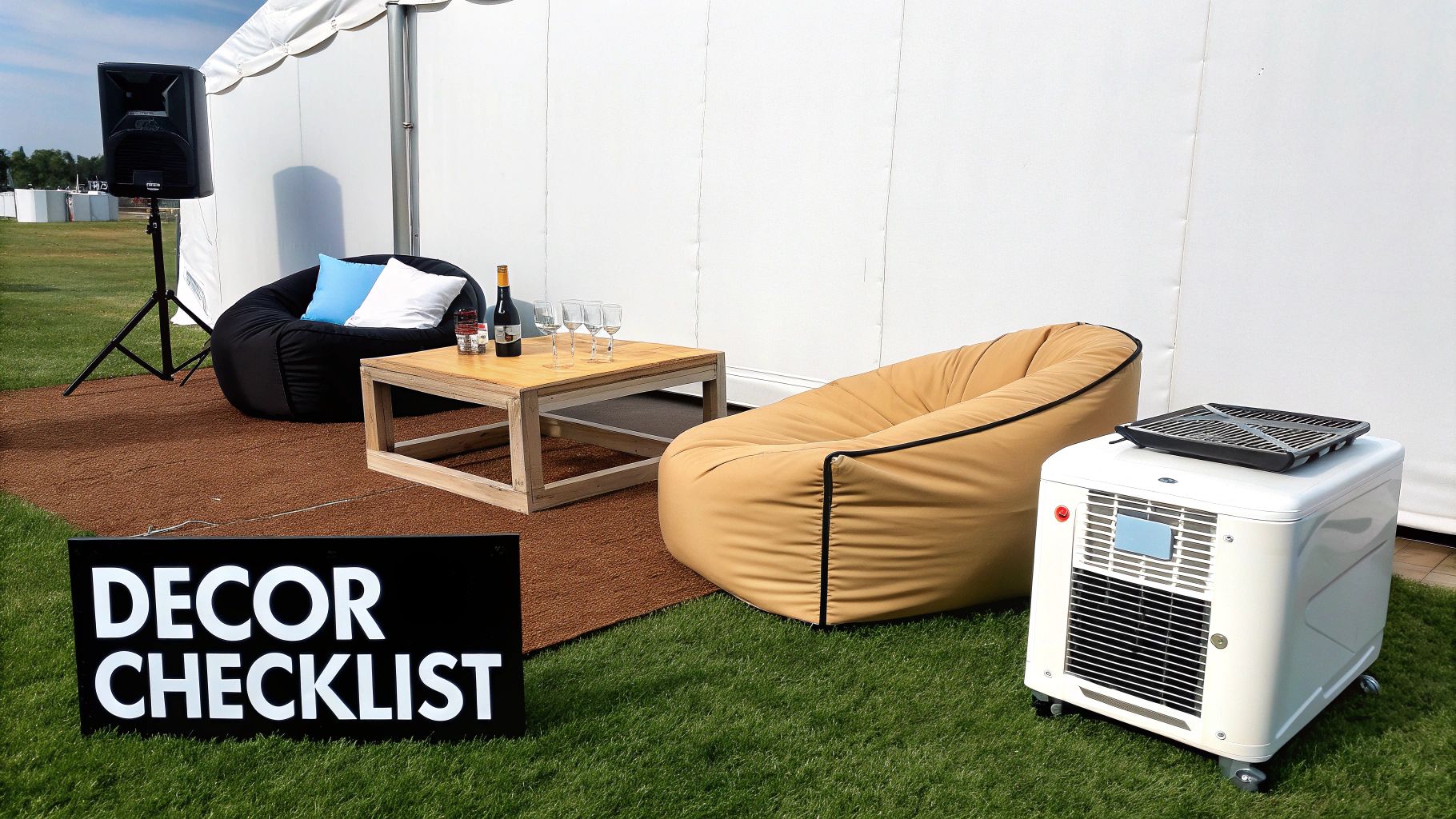 Outdoor event setup with bean bag chairs, a wooden table, speaker, and portable heater beside a white tent and 'DECOR CHECKLIST' sign.