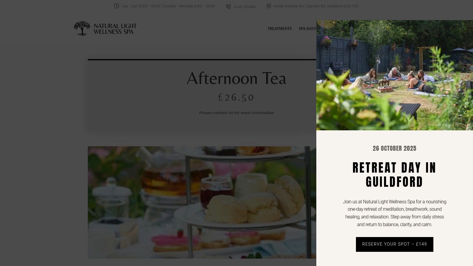 A serene afternoon tea setup at Natural Light Wellness Spa, featuring a tiered stand with sandwiches, scones, and cakes.