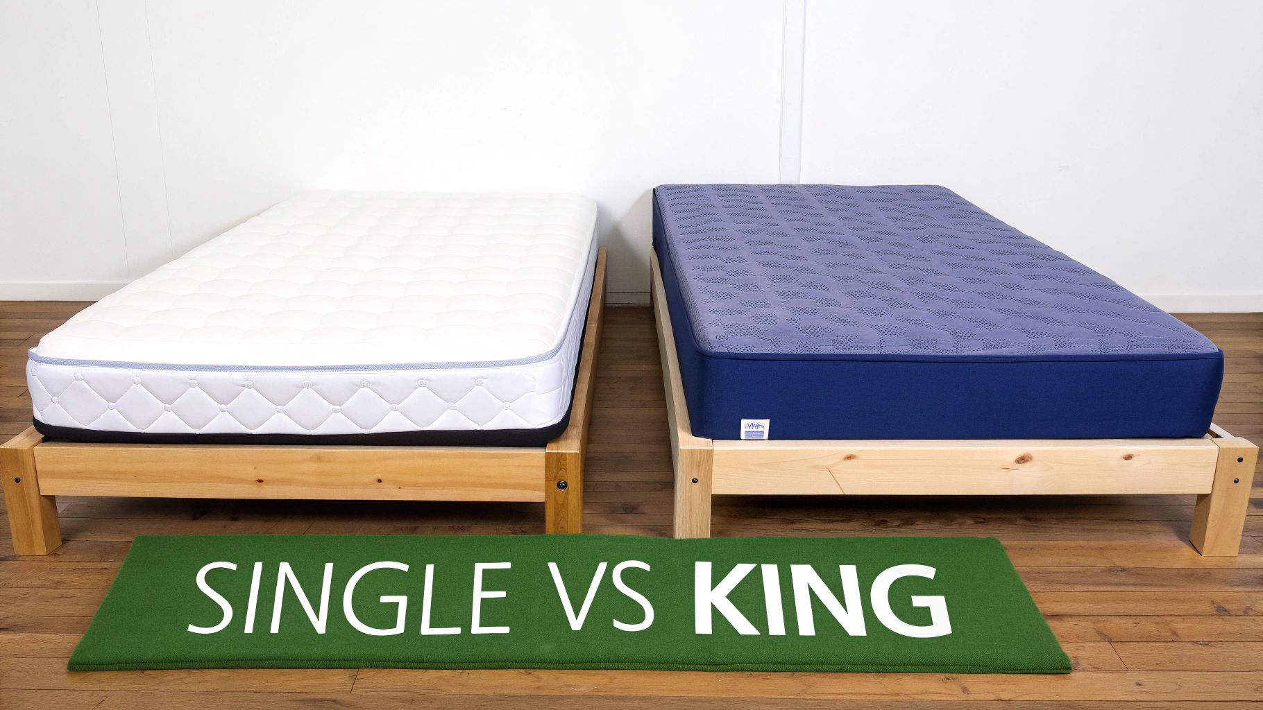 Two single mattresses, one white and one purple, on wooden frames with a 'SINGLE VS KING' mat.