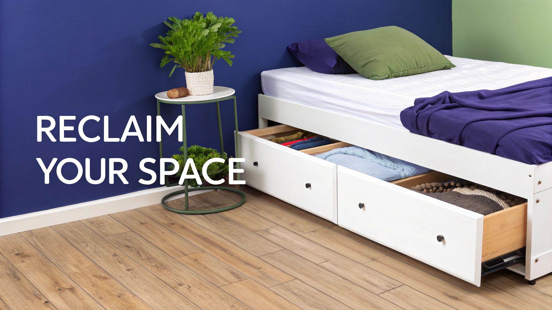 A white bed base with three pull-out storage drawers, one open revealing items, against a blue wall.