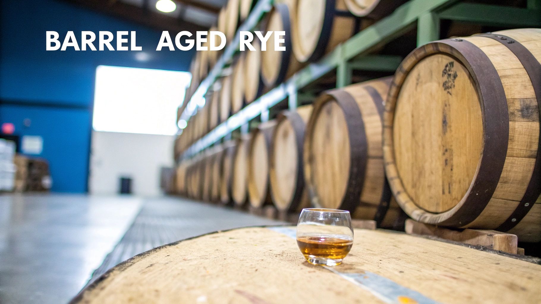 A glass of barrel-aged rye whiskey on a wooden barrel in a warehouse of stacked barrels.