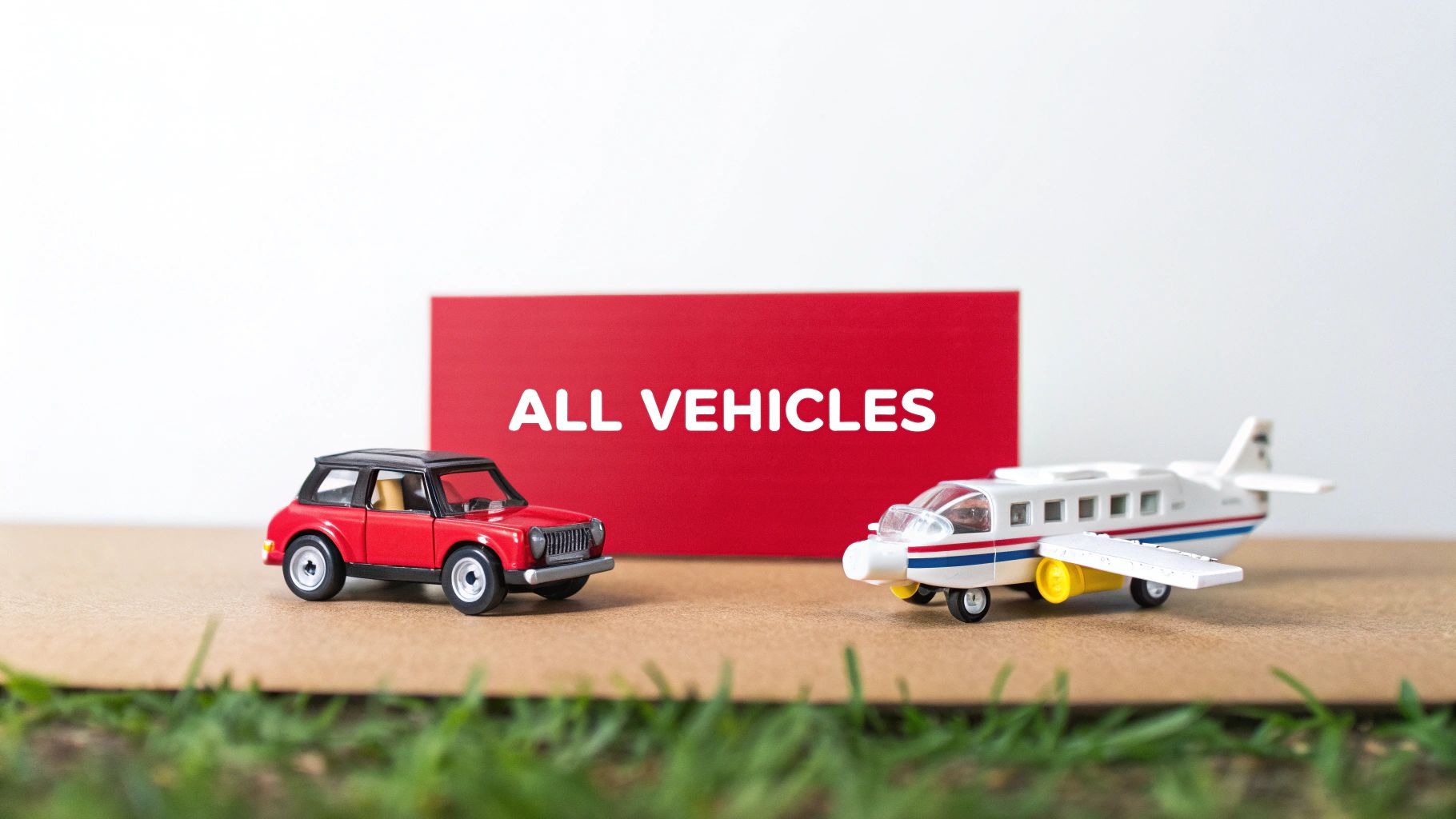 A toy red car and white airplane with an 'ALL VEHICLES' sign in the background.