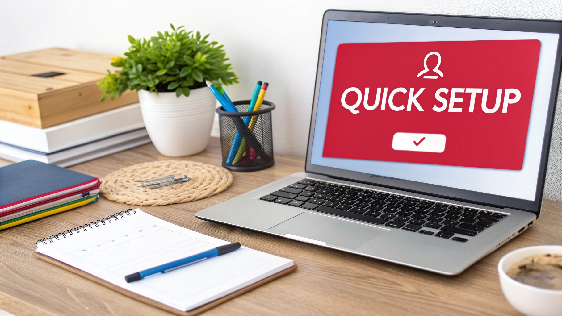 A laptop displaying 'QUICK SETUP' on a red screen, surrounded by desk essentials.