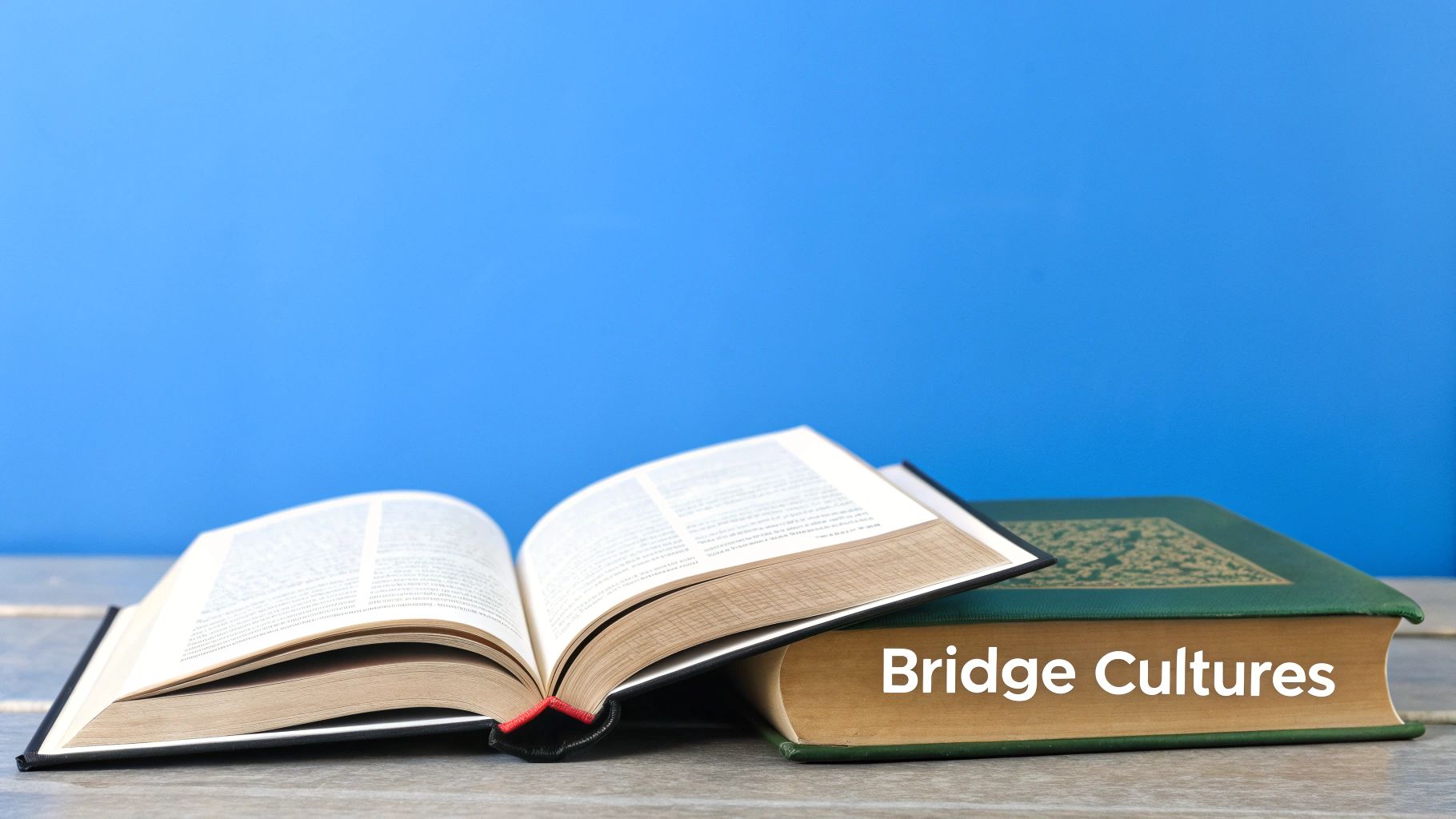 An open book and a closed green book with 'Bridge Cultures' on its side, against a blue background.