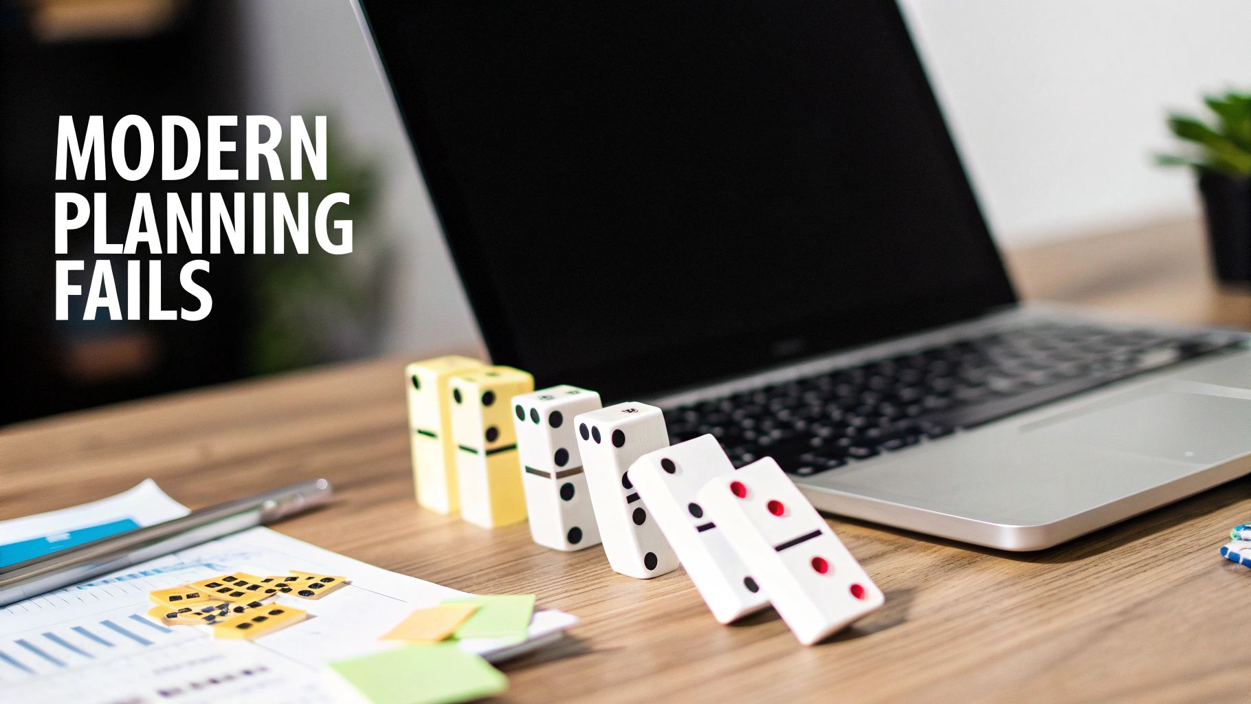 Dominoes falling on a wooden desk next to a laptop, symbolizing modern planning failures.