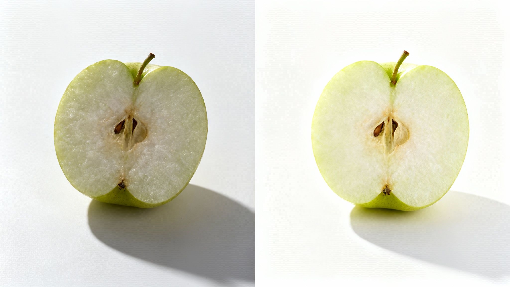 שני חצאי תפוח ירוק בהיר ורענן מונחים על משטח לבן, מציגים את הגרעינים והליבה.