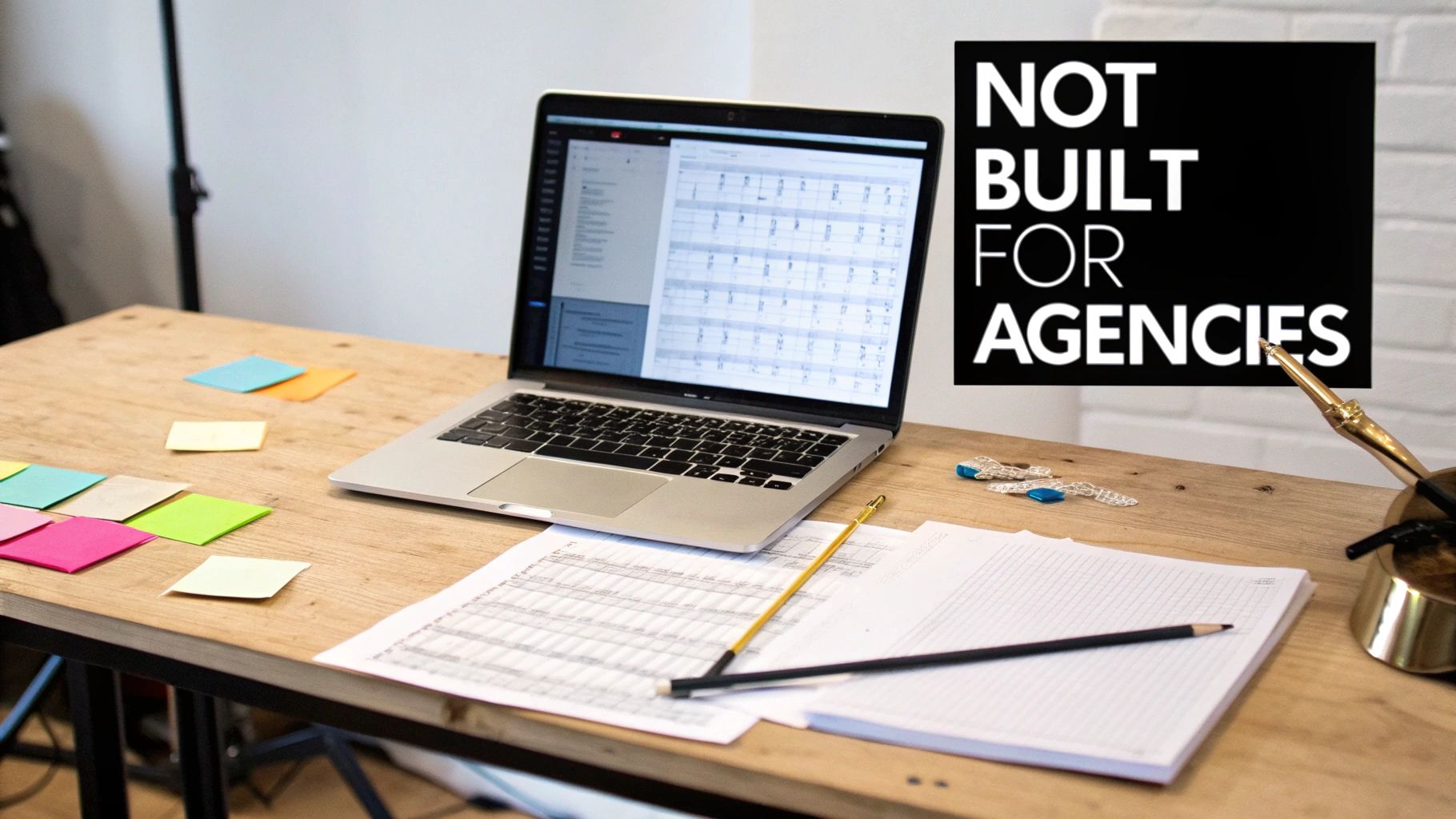 A wooden desk featuring a laptop displaying a spreadsheet, colorful sticky notes, and office supplies.