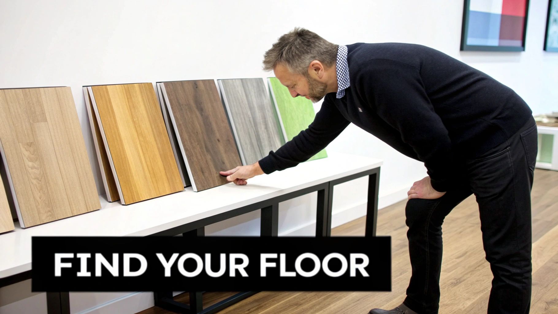 A man in a black sweater examines various flooring samples, including wood and textured options, on a display table.