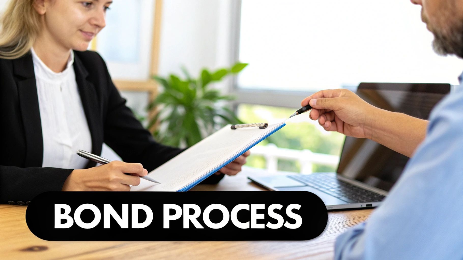A business professional explains bond process documents to a client, with a pen ready to sign.