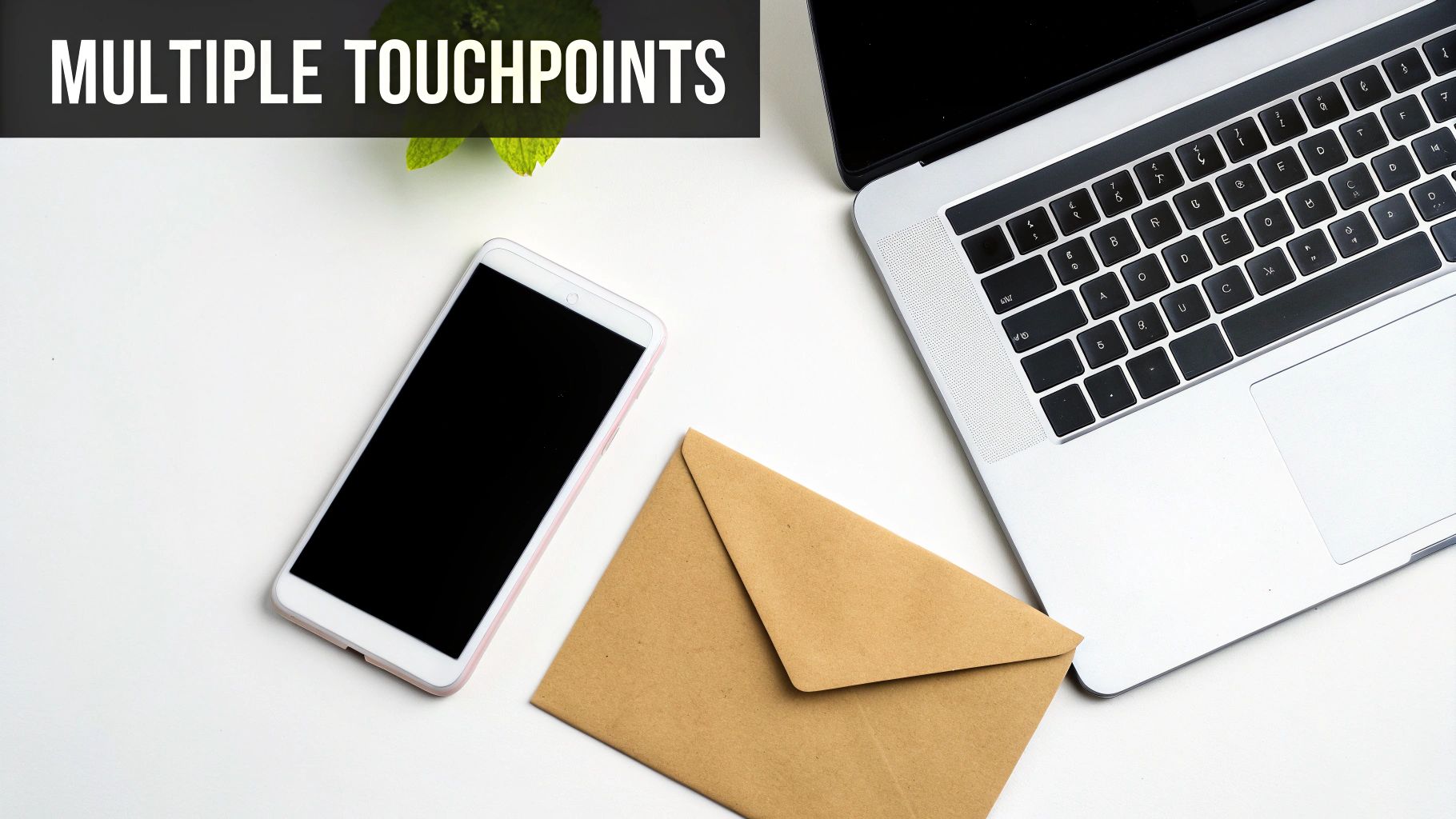 Flat lay of a white desk with a smartphone, laptop, and brown envelope representing multiple communication channels.