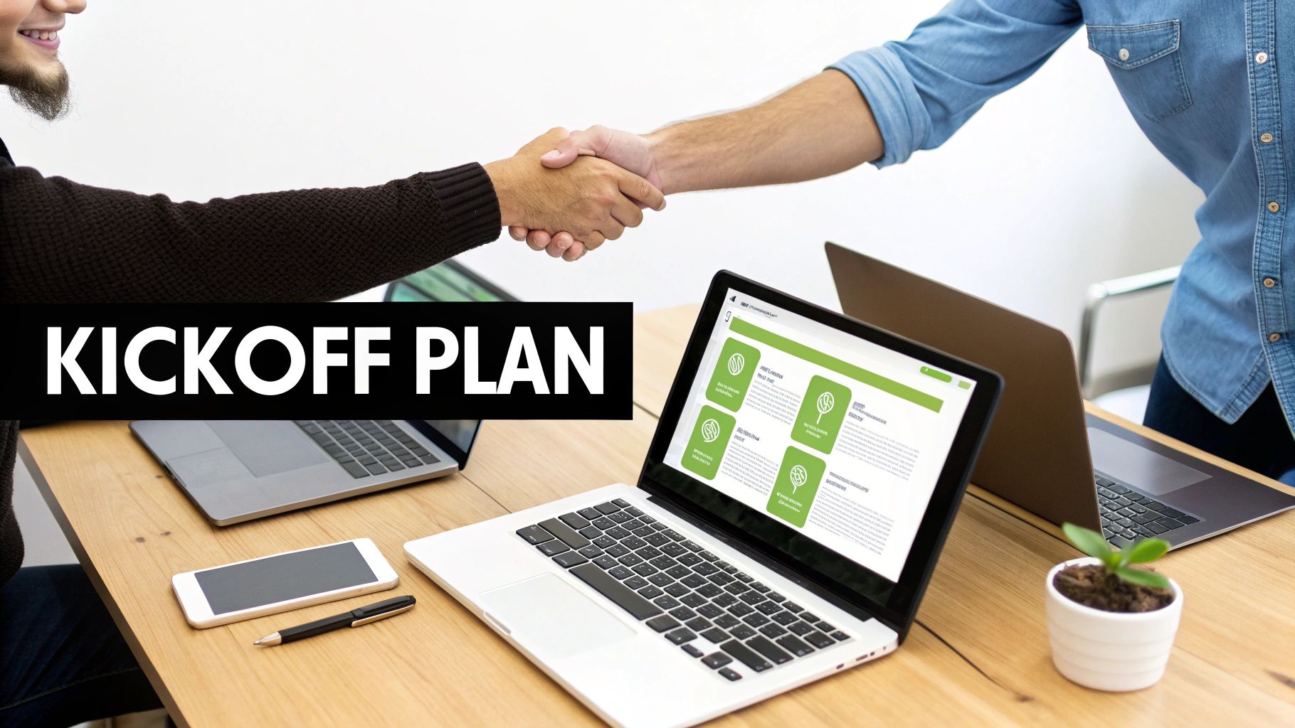 Two men shaking hands over a desk with laptops and 'KICKOFF PLAN' text, signifying a business agreement.
