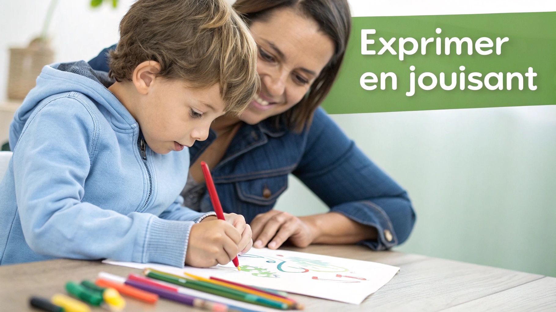 Un jeune garçon dessine avec enthousiasme sur une feuille, sa mère souriante l'encourage tendrement. Des crayons colorés sont sur la table.